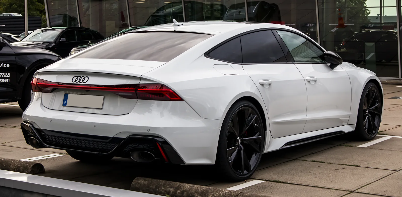 Audi RS7 Sportback 2026 blanche vue trois quarts arrière parking berline sportive