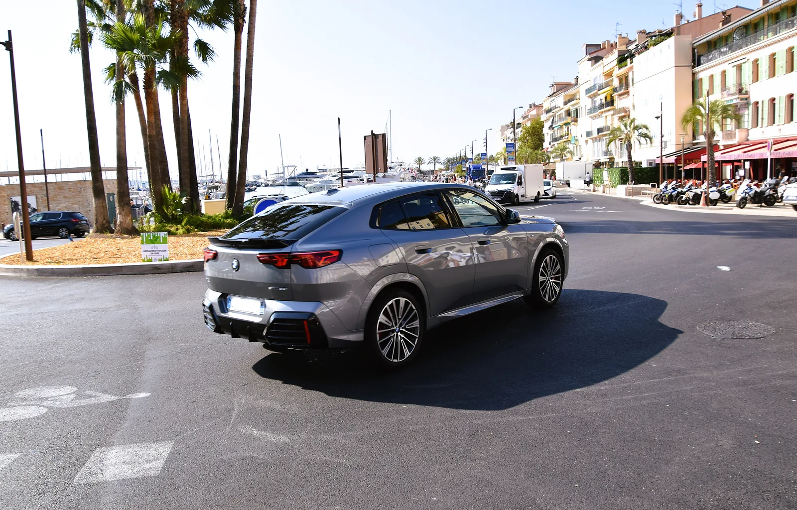 BMW X2 sDrive20i (U10) en gris vue arrière 3/4 à Cannes — silhouette coupé-SAC, prise de vue en ville avec palmiers