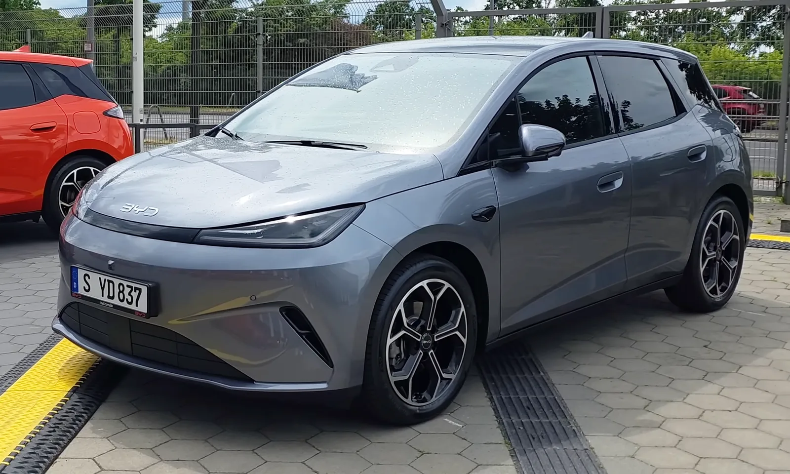 BYD Dolphin G DM-i 2026 vue 3/4 avant citadine hybride rechargeable grise stationnée dans la rue