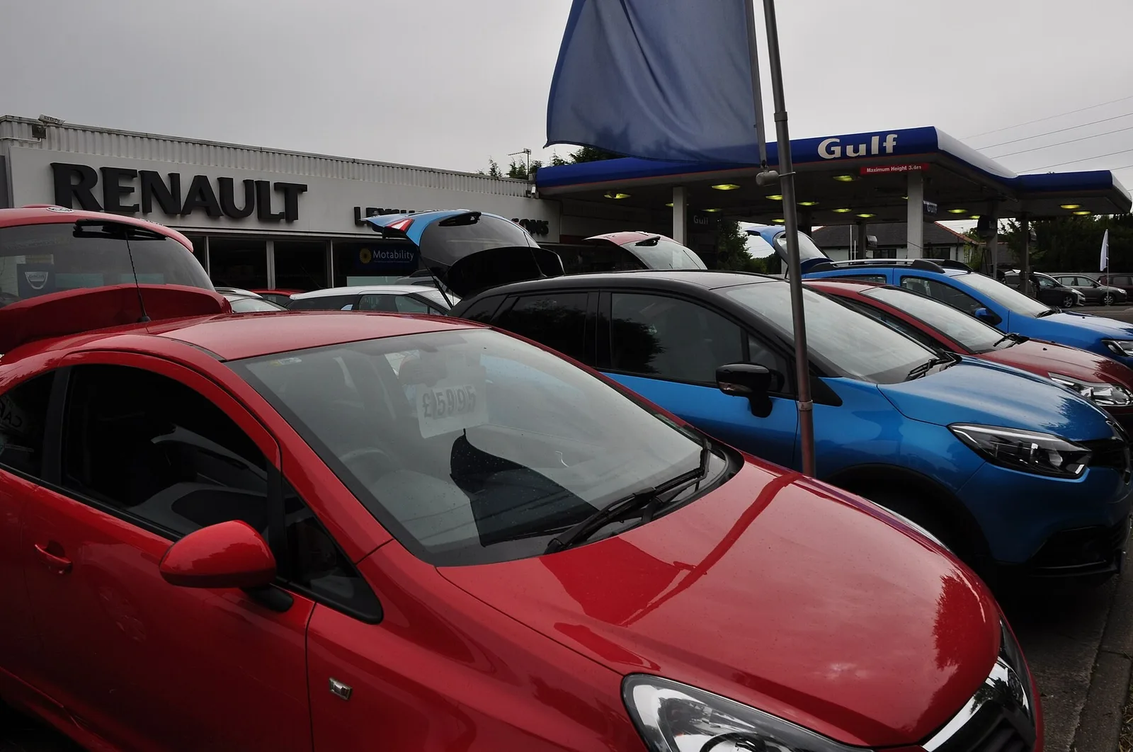 Parc de voitures d'occasion devant une concession Renault, où la reprise estimée en ligne est confirmée après inspection