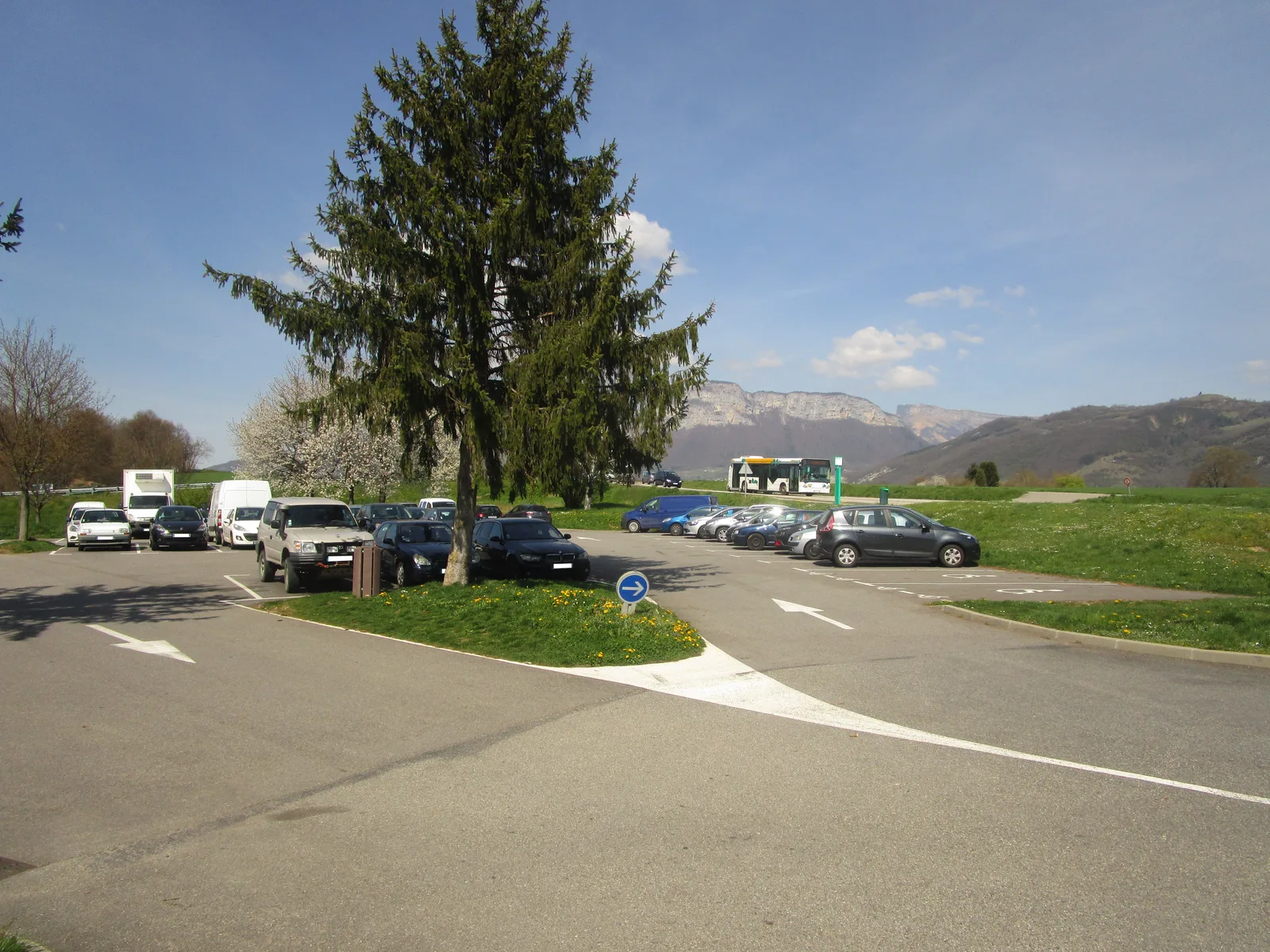 Aire de covoiturage avec plusieurs véhicules stationnés en bord de route de campagne