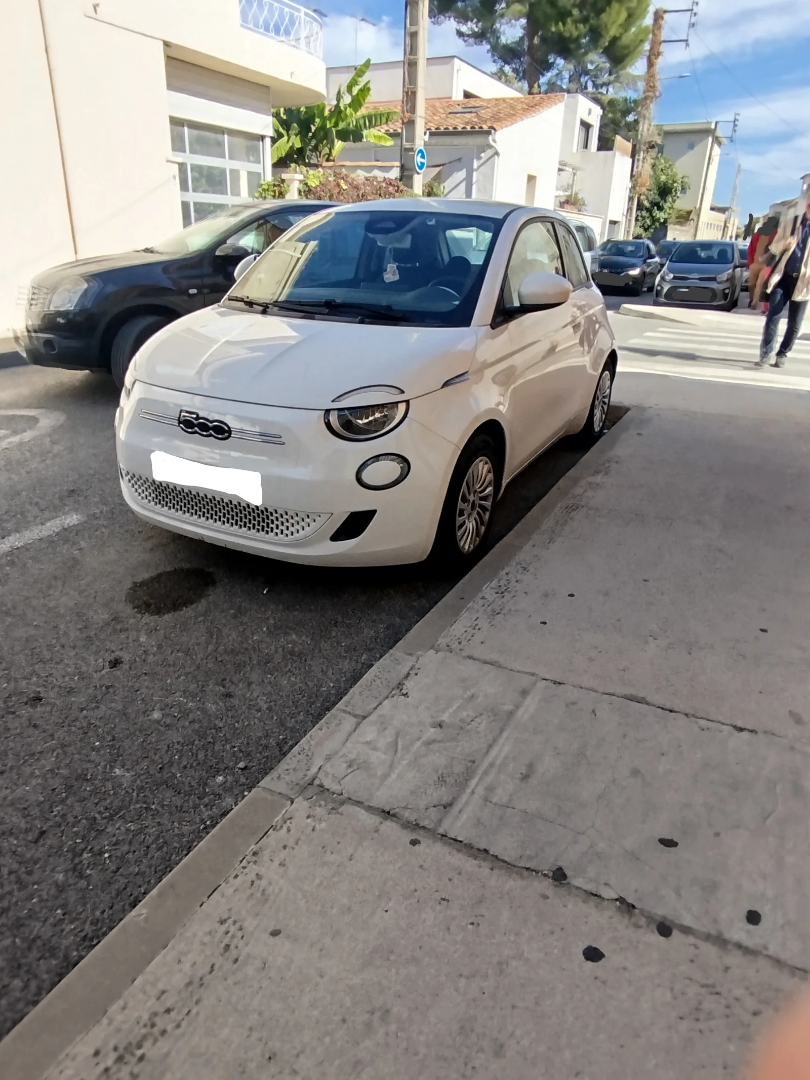 Fiat 500e 2026 vue de face blanche ville italienne style design rétro