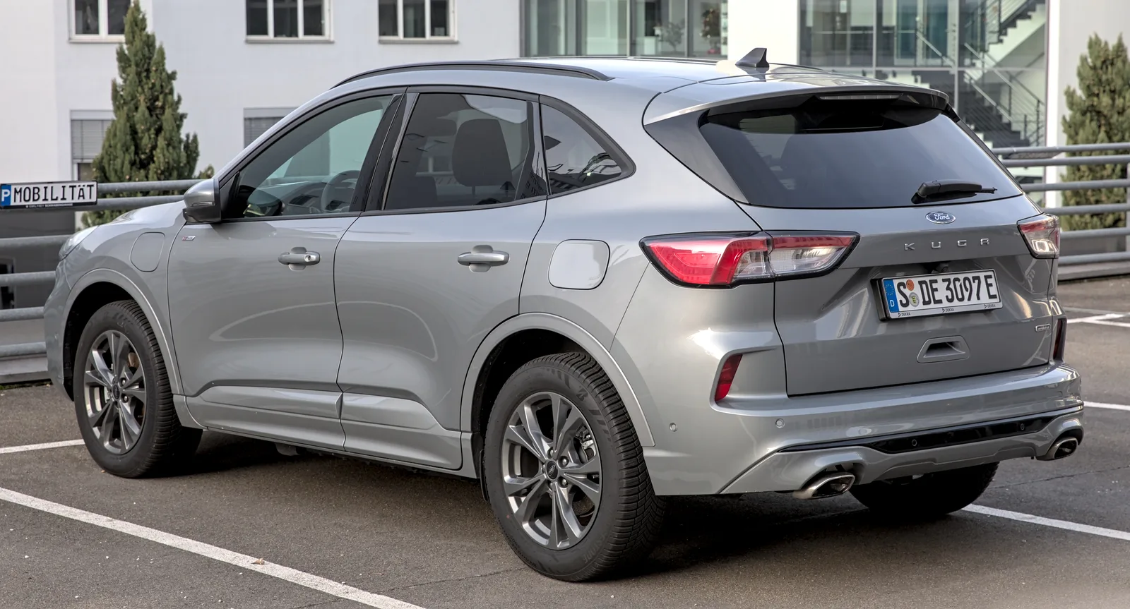 Ford Kuga PHEV 2026 gris argent, vue 3/4 arrière, plaque DE, badge électrique vert