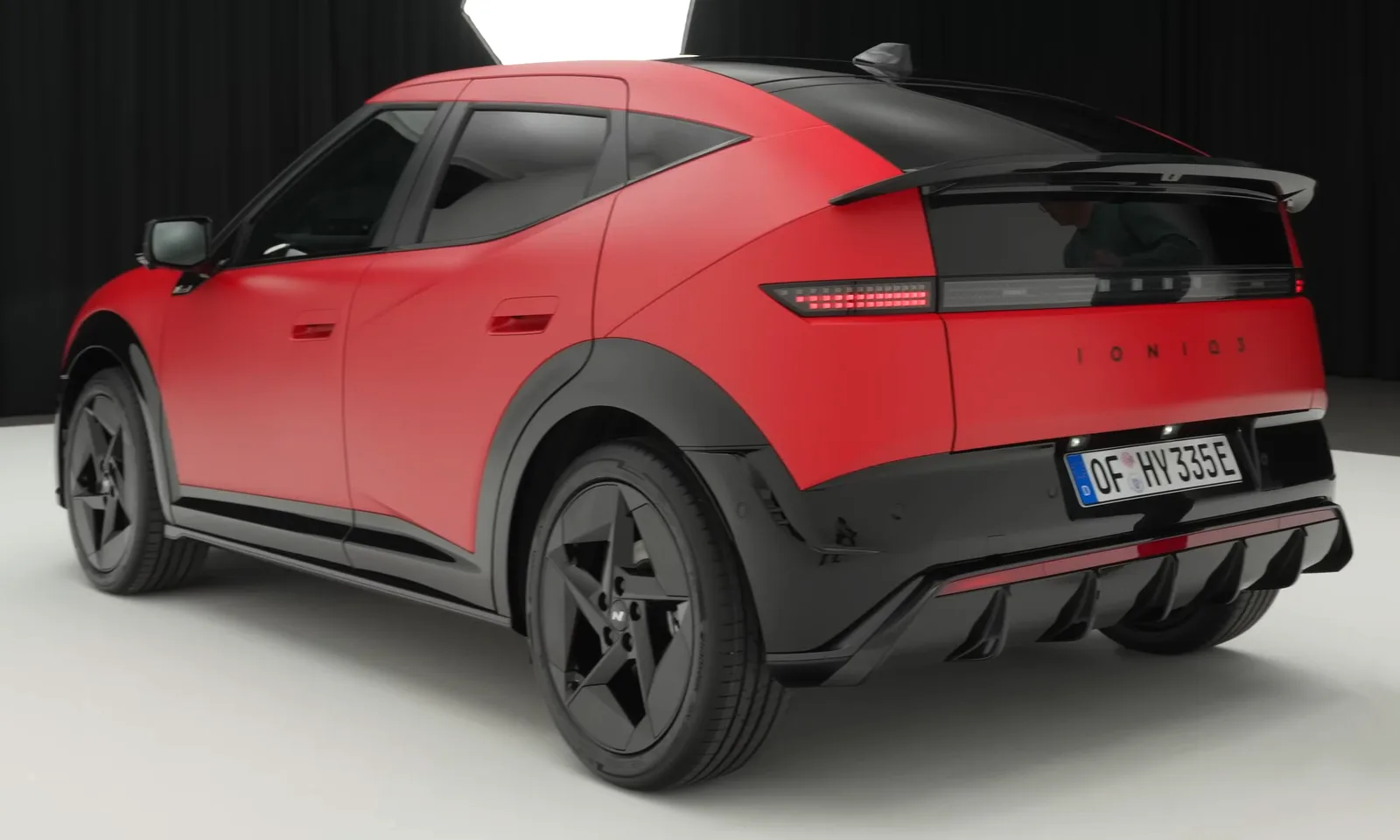 Hyundai Ioniq 3 N Line rouge mat vue de trois quarts arrière avec diffuseur noir et becquet, compacte électrique 2026