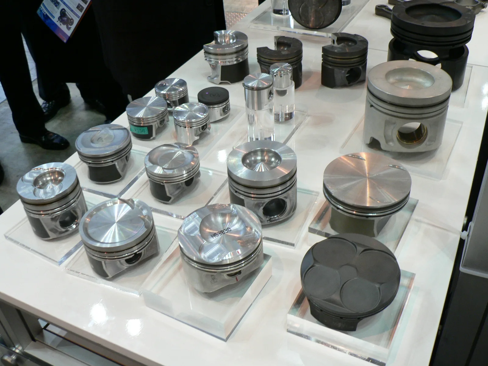 Pistons de moteurs diesel et essence pour injection directe, exposés sur présentoir technique — MAHLE