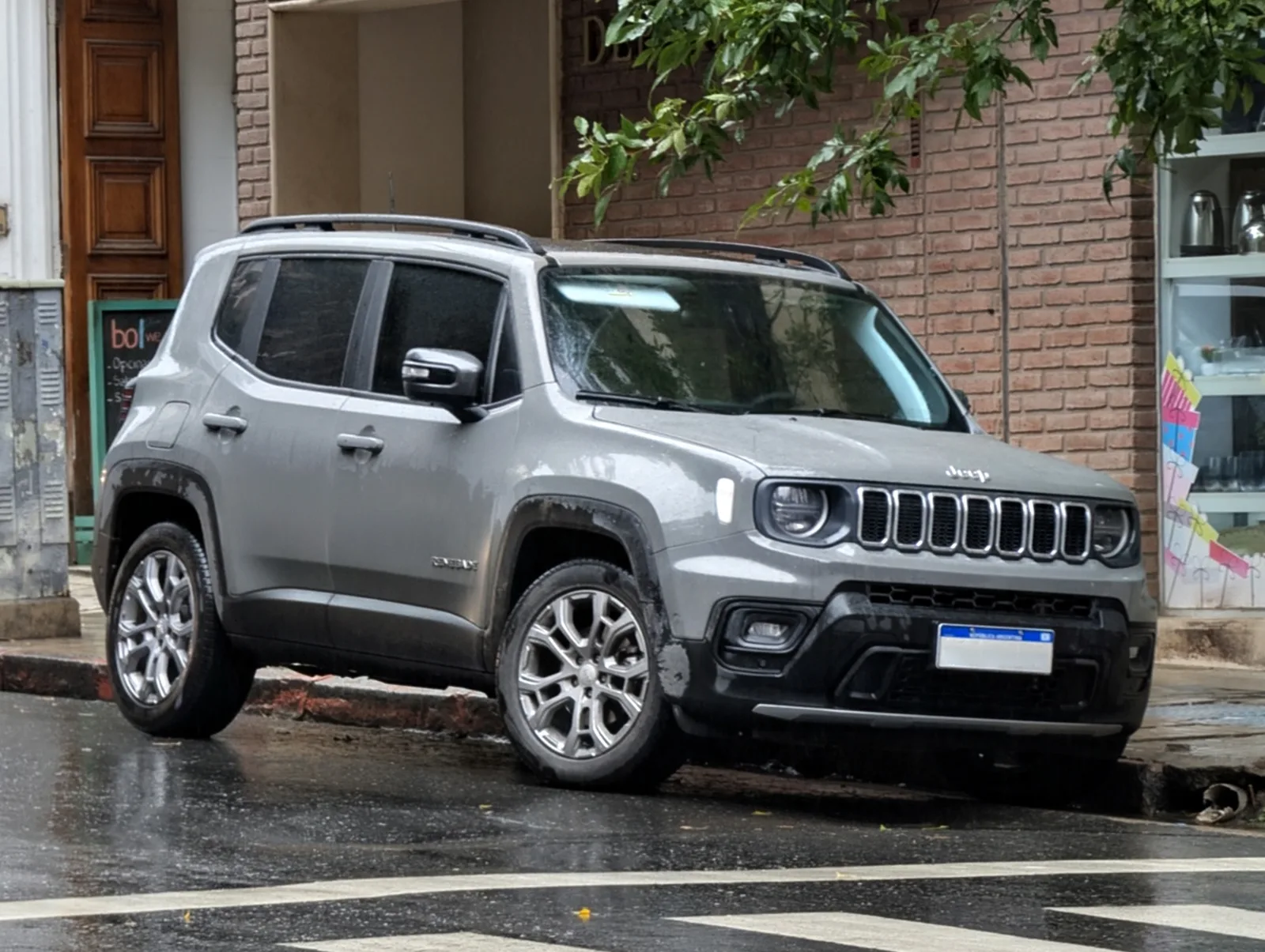 Jeep Renegade 2026 Longitude gris vue trois quarts avant rue urbaine mouillée