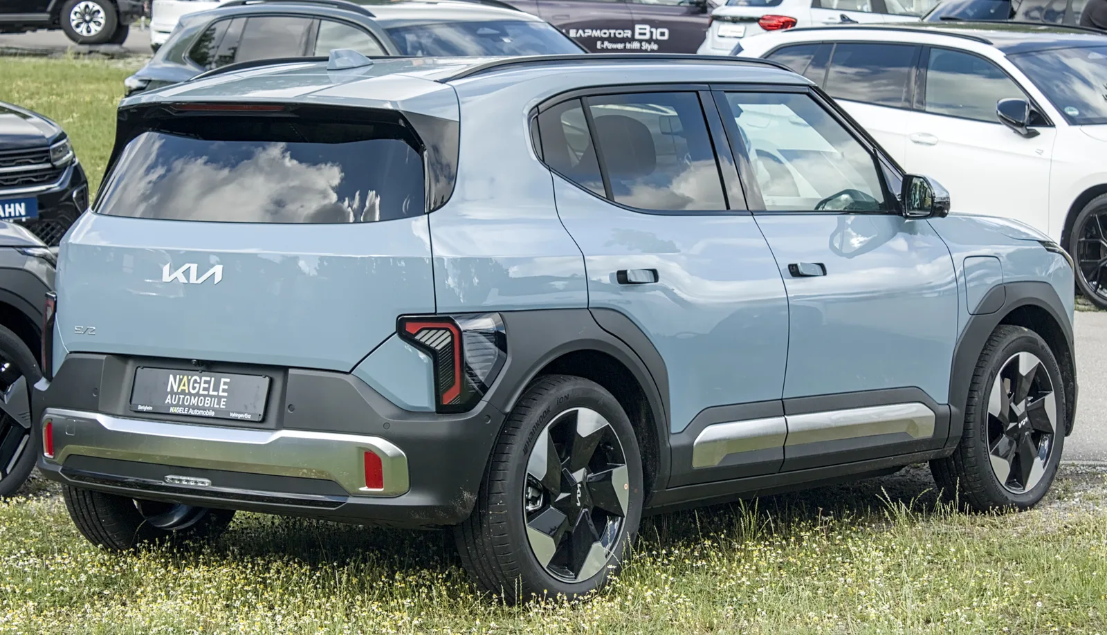 Kia EV2 2026 vue de côté SUV électrique bleu-gris jantes noires garage extérieur