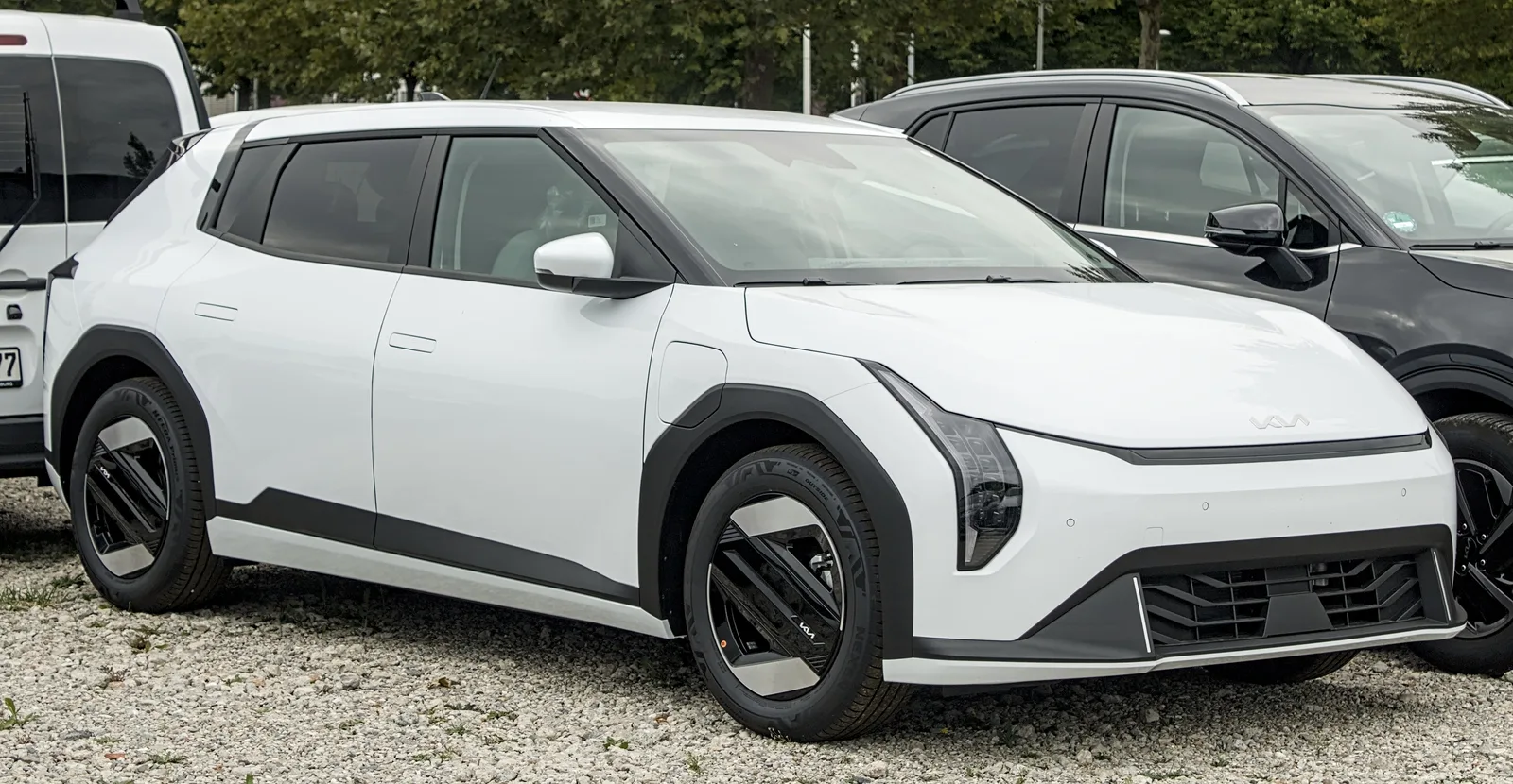 Kia EV4 cinq portes blanche vue de trois quarts avant sur un parking, compacte électrique fabriquée en Slovaquie