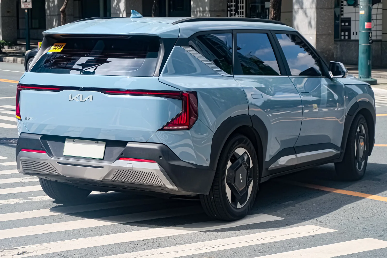 Kia EV5 2026 vue trois quarts arrière SUV électrique bleu clair feux LED