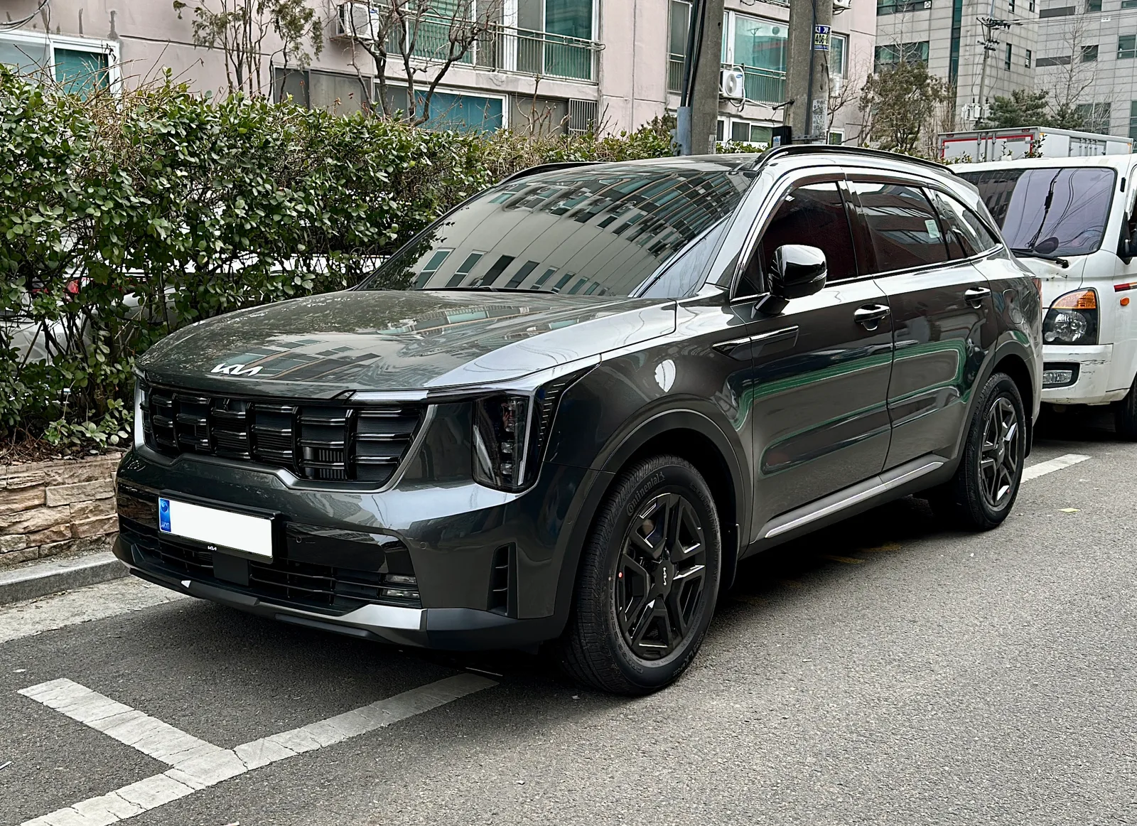 Kia Sorento MQ4 Hybrid 2024 vue extérieure 3/4 avant — version hybride rechargeable avec badge PHEV et trappe de recharge visible