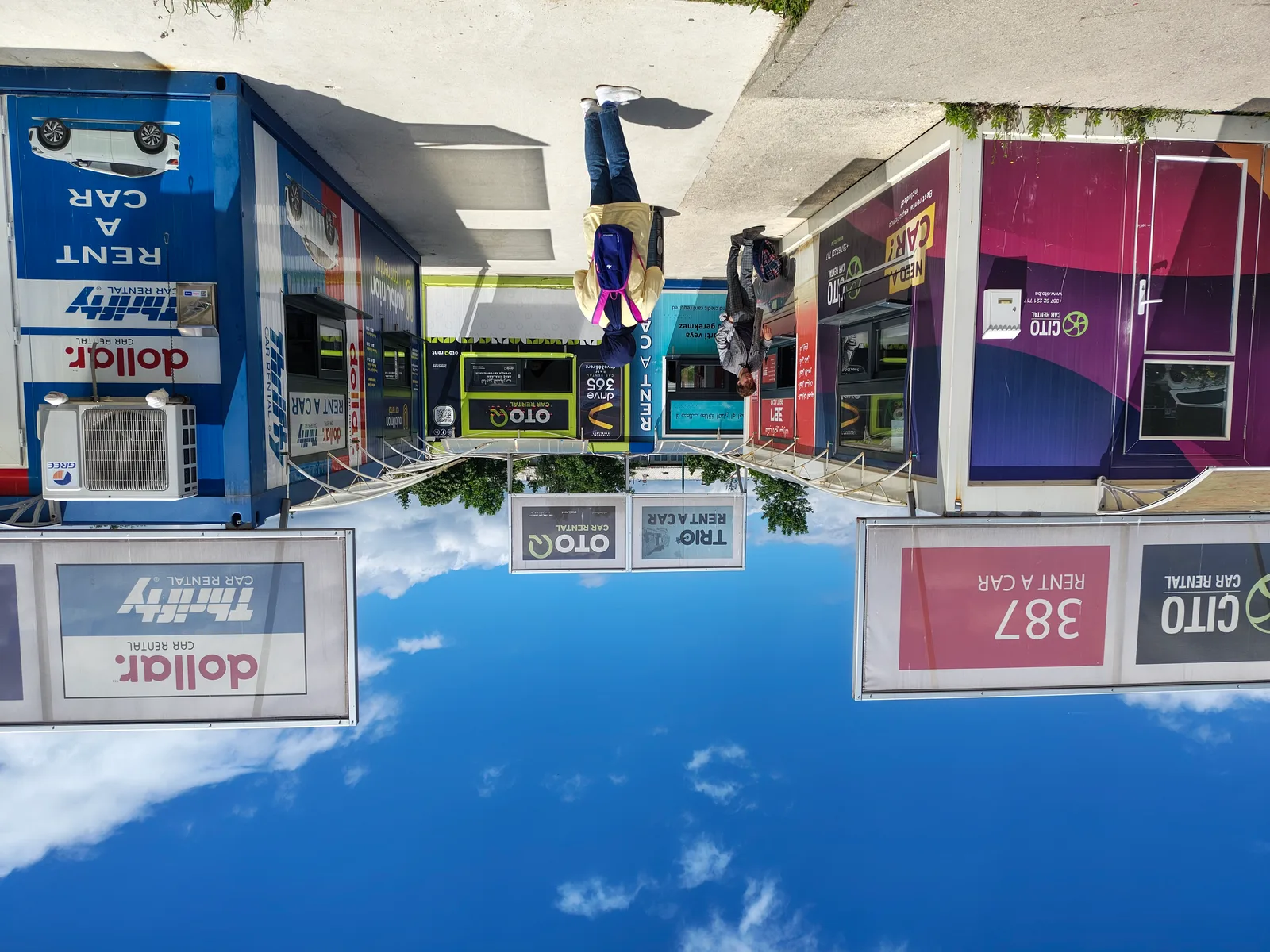 Kiosques de location de voitures dans un aéroport européen — plusieurs agences côte à côte avec files d'attente