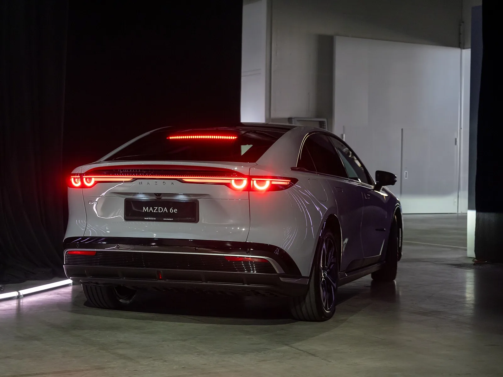 Mazda 6e blanche vue arrière avec bandeau de feux lumineux continu et coffre fermé