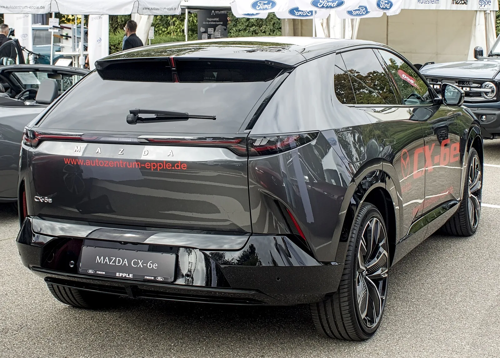 Mazda CX-6e gris foncé vu de trois quarts arrière, SUV électrique de 4,85 m avec coffre de 468 litres