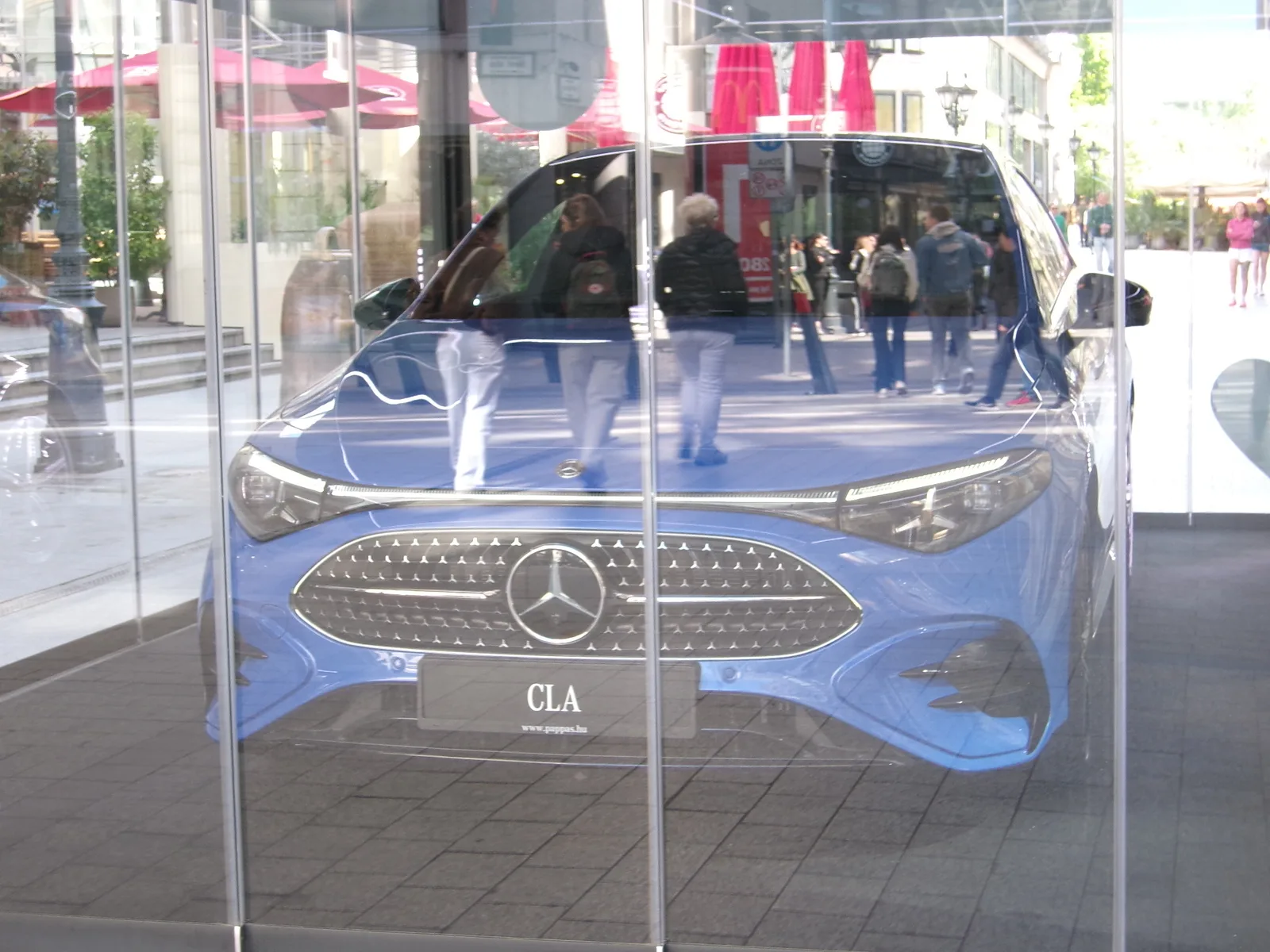 Mercedes CLA 2026 bleue vue avant face grille étoile vitrine Budapest showroom