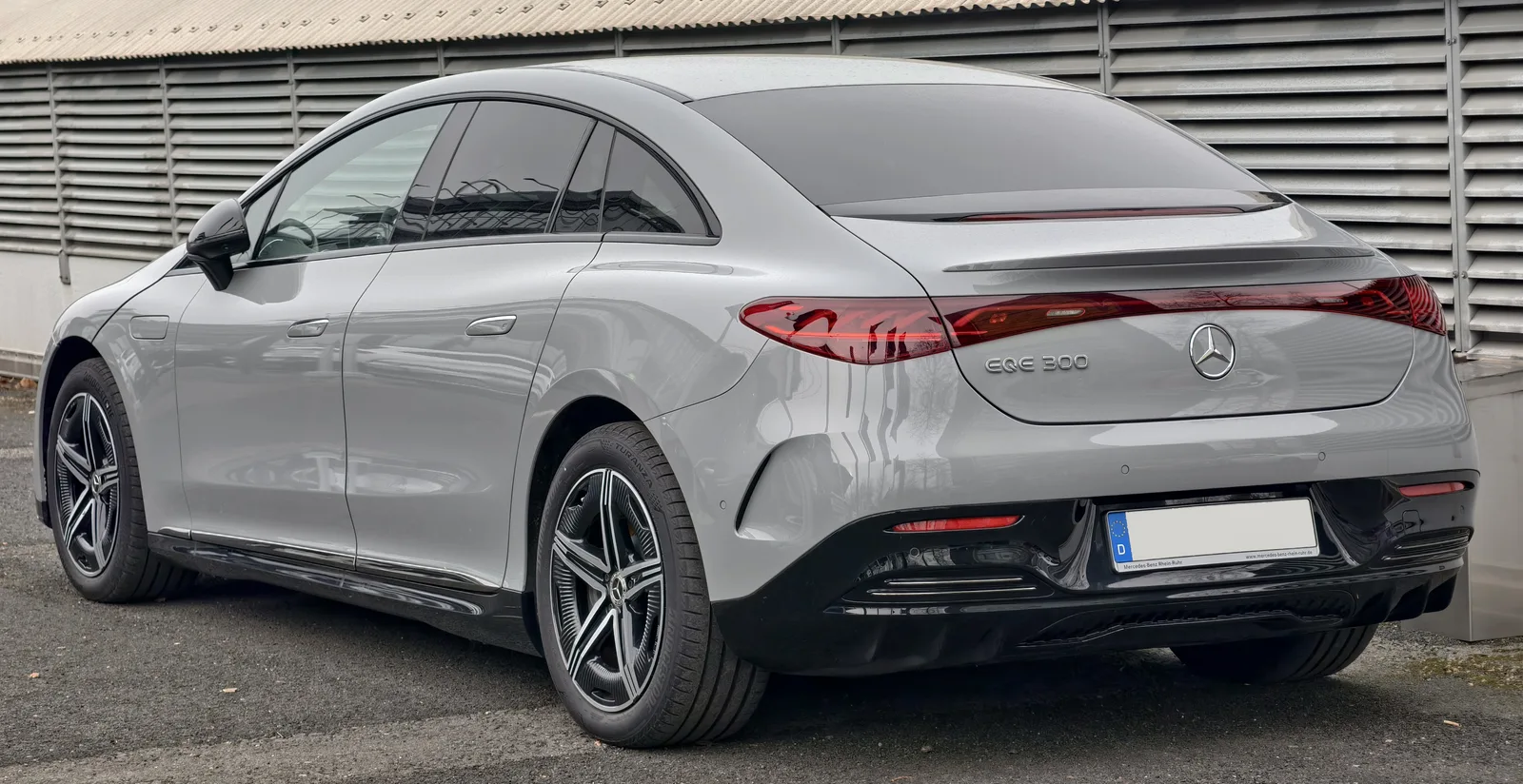 Mercedes EQE 300 vue arrière trois quarts berline électrique grise badge EQE 300 visible sur le coffre