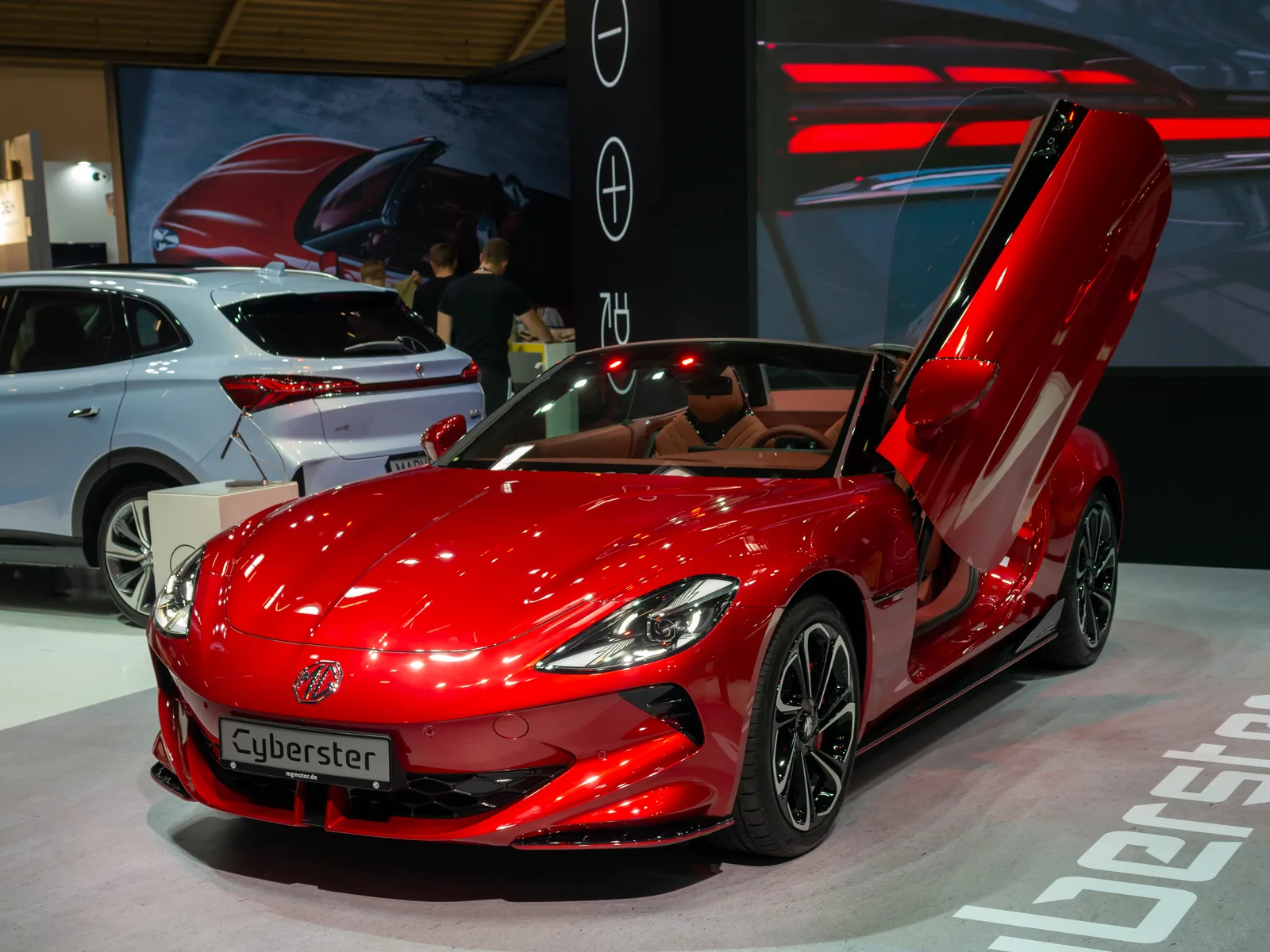 MG Cyberster 2026 vue avant roadster électrique rouge portes papillon ouvertes habitacle visible
