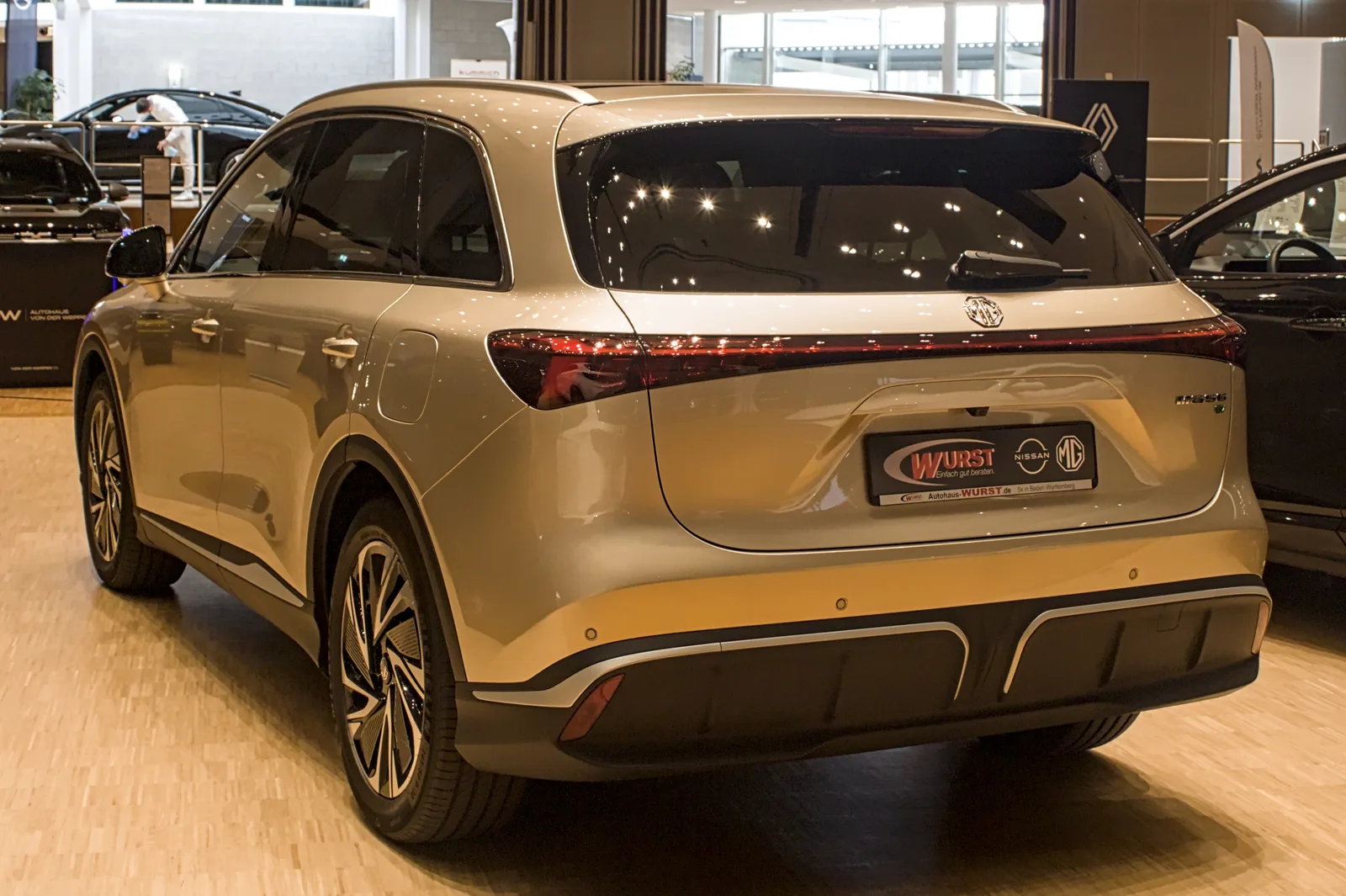 MG S6 EV beige vu de trois quarts arrière en concession, SUV électrique familial au coffre de 674 litres
