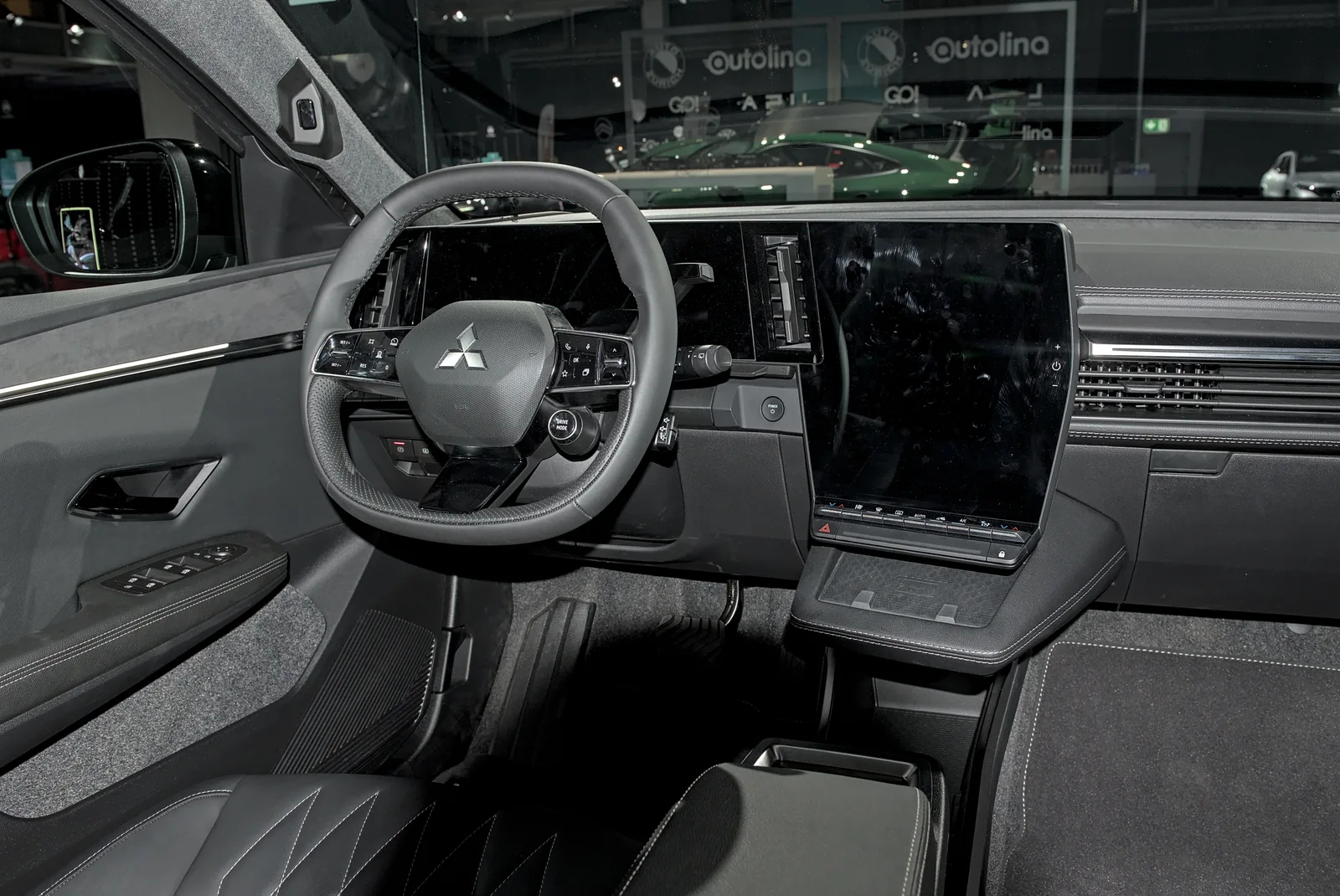 Planche de bord du Mitsubishi Eclipse Cross électrique avec volant à logo Mitsubishi, écran central vertical et instrumentation numérique