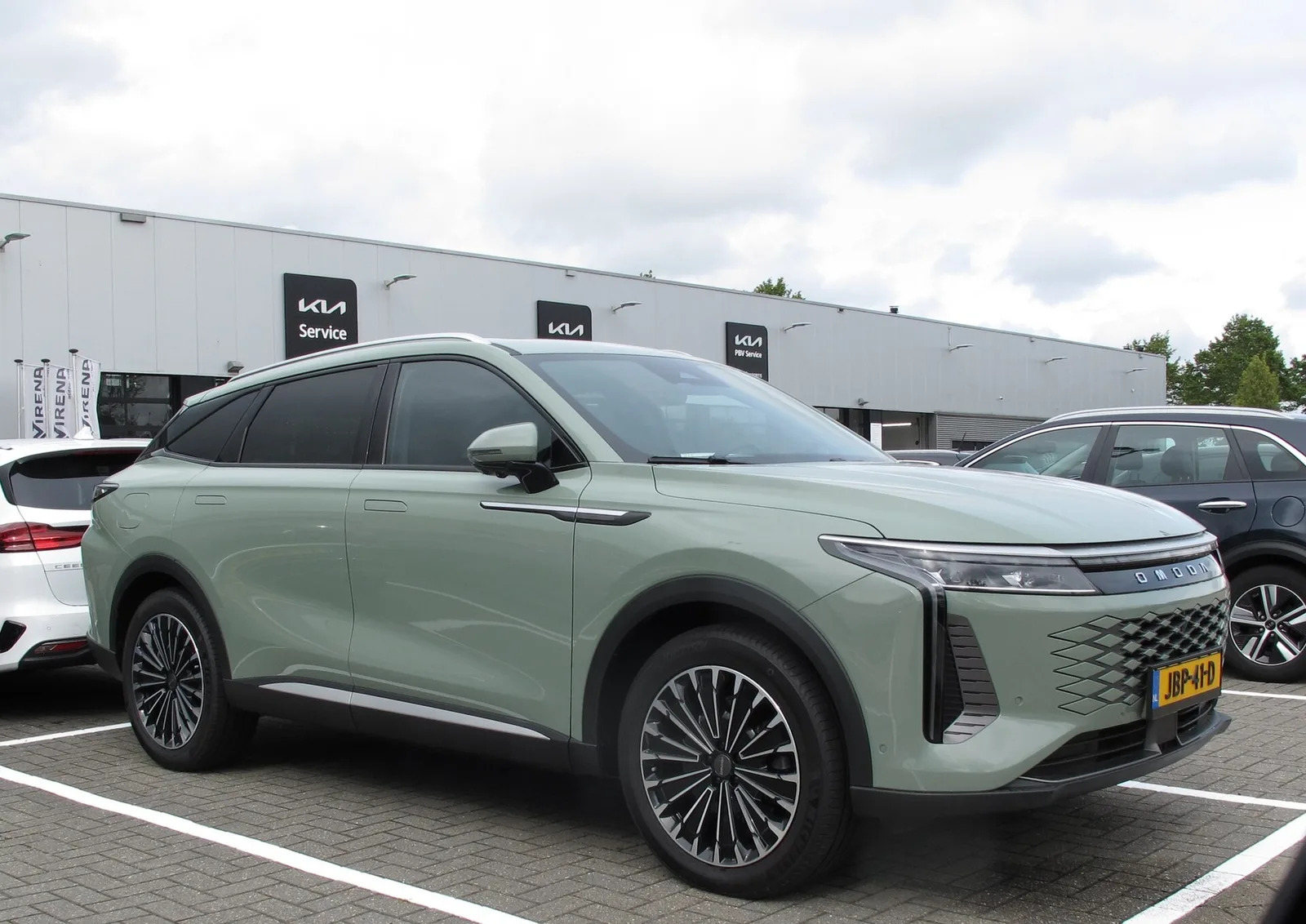Omoda 9 SHS-P vert amande garé devant une concession, grand SUV hybride rechargeable à 145 km d'autonomie électrique