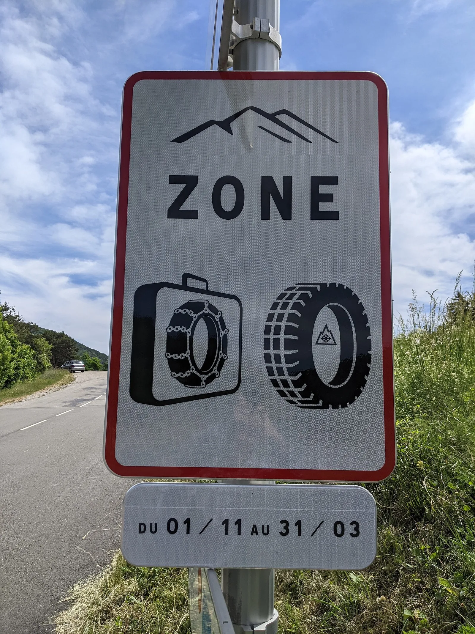Panneau de zone à équipement hivernal obligatoire avec pictogrammes chaînes et pneu neige, valable du 1er novembre au 31 mars