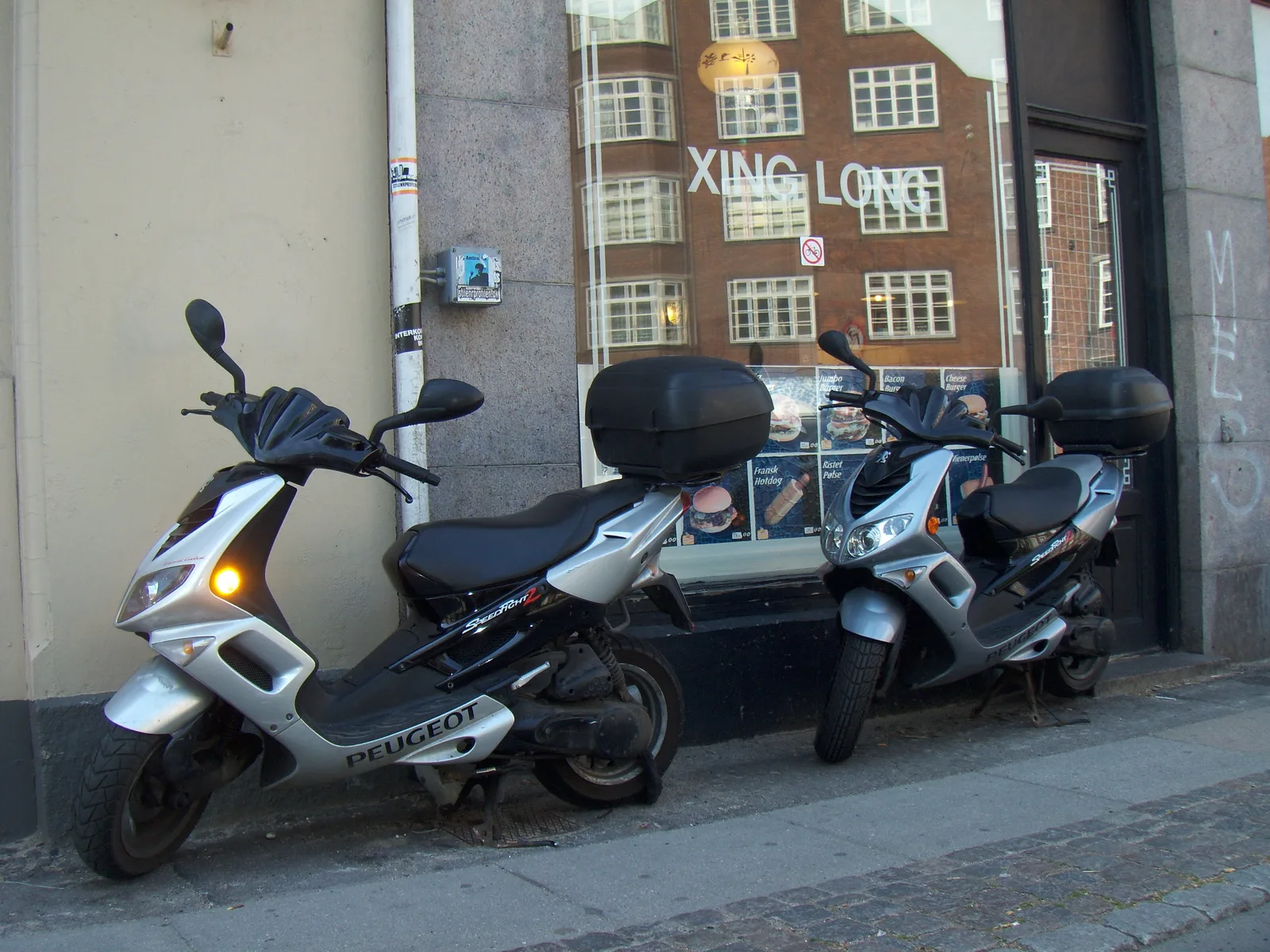 Deux scooters Peugeot 50cc garés en ville — les véhicules concernés par le permis AM