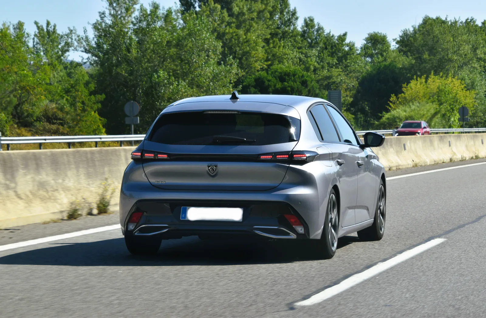 Peugeot 308 2026 vue arrière grise sur autoroute de nuit