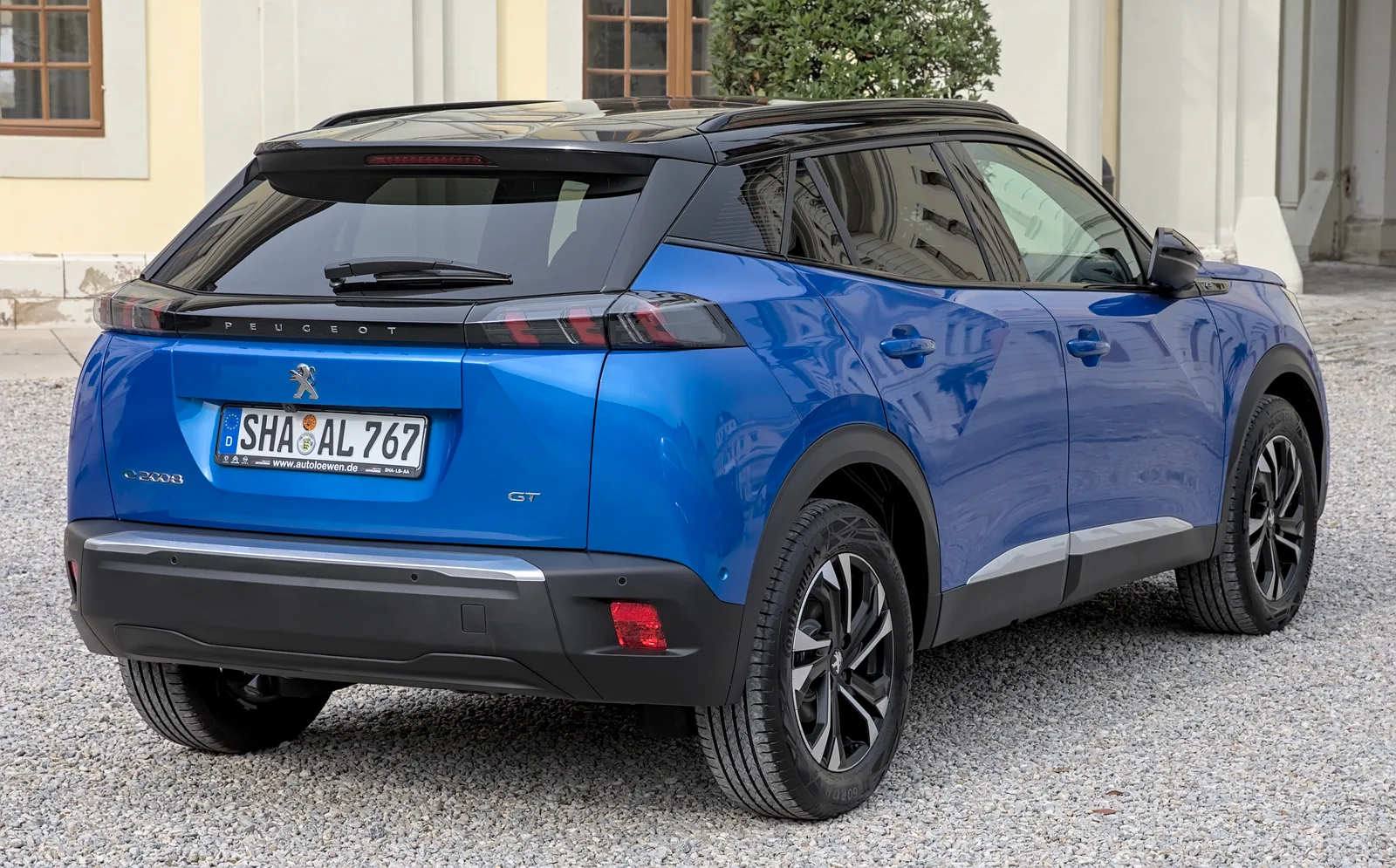 Peugeot e-2008 électrique 2026 vue trois-quarts arrière — ligne de toit tendue et feux signature