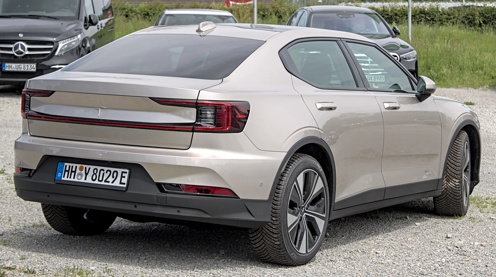 Polestar 2 restylée couleur champagne vue de trois quarts arrière sur un parking, berline électrique fastback à 659 km WLTP