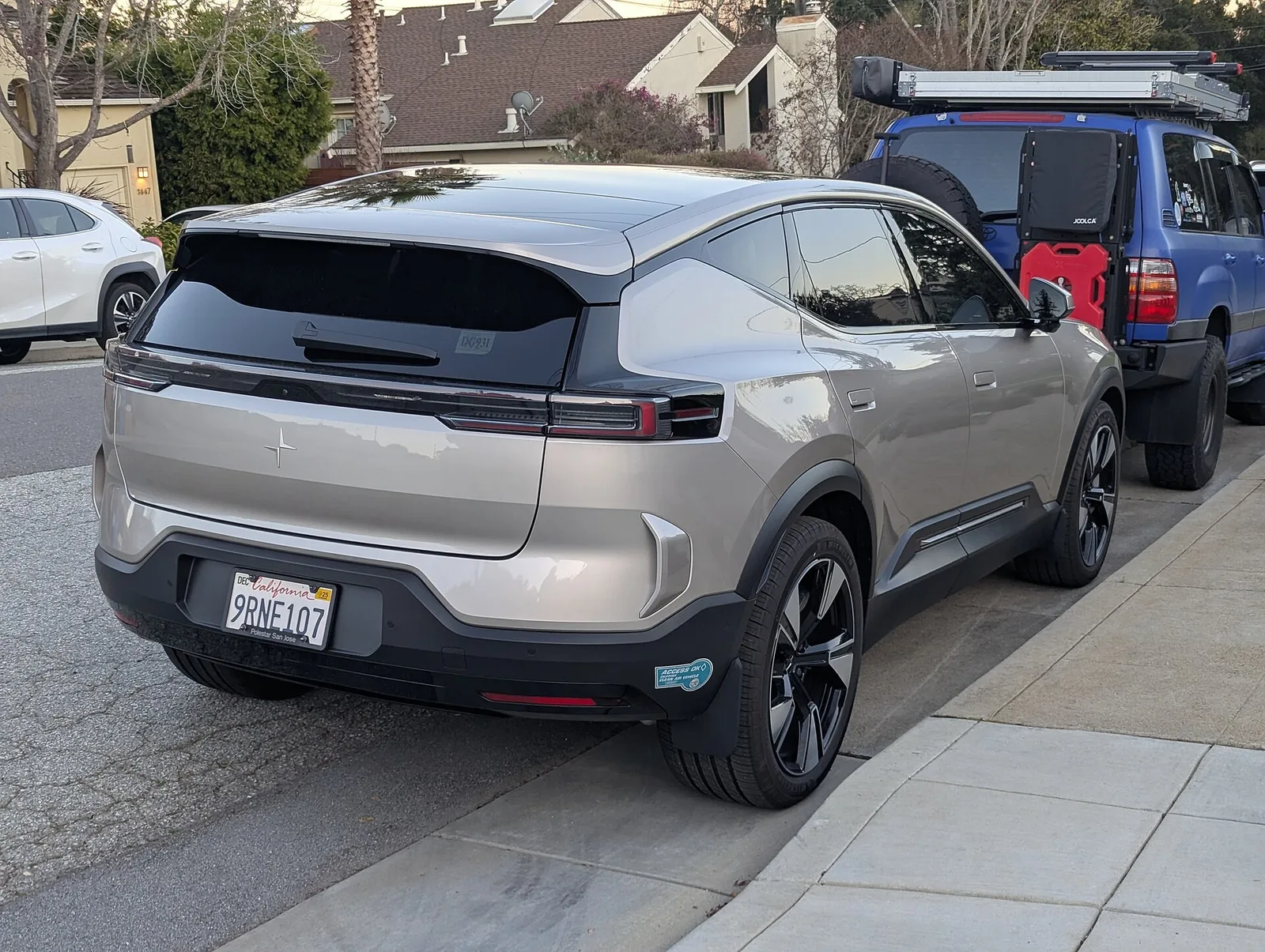 Polestar 3 gris clair vu de trois quarts arrière garé dans une rue résidentielle, SUV électrique de 4,90 m