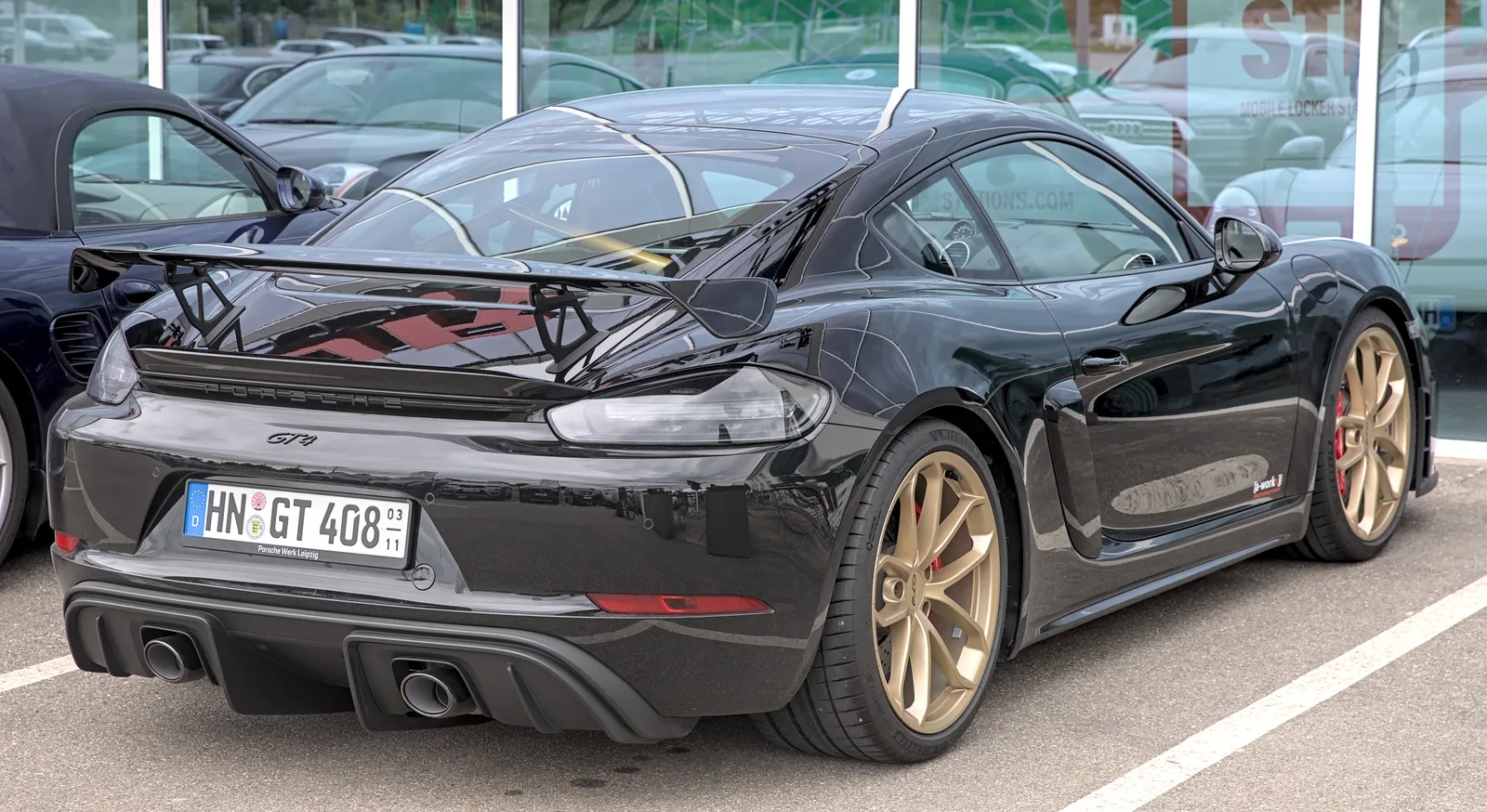 Porsche 718 Cayman GT4 noir jantes or aileron arrière sportive