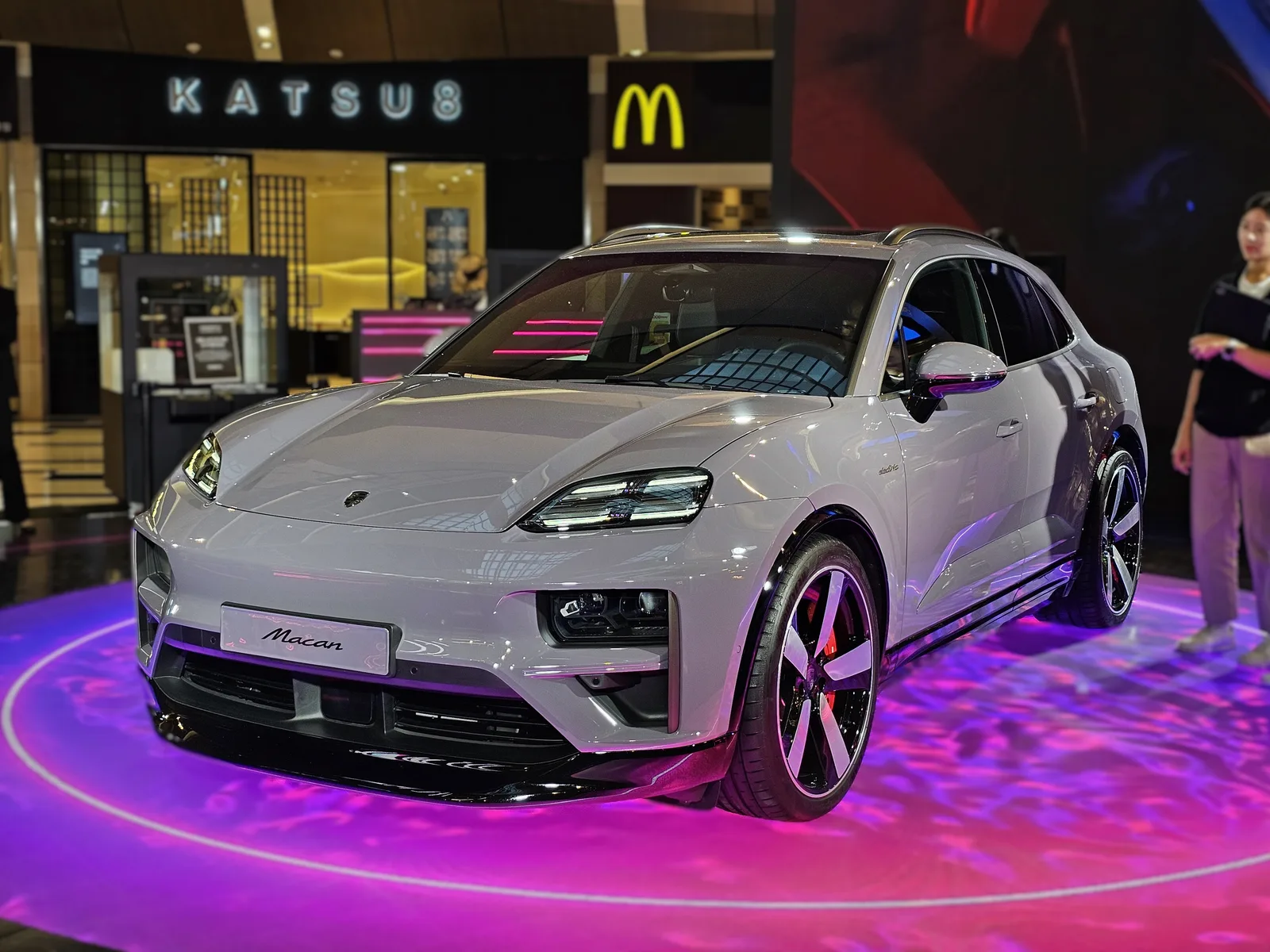 Porsche Macan électrique grise vue de trois quarts avant, phares à quatre points lumineux