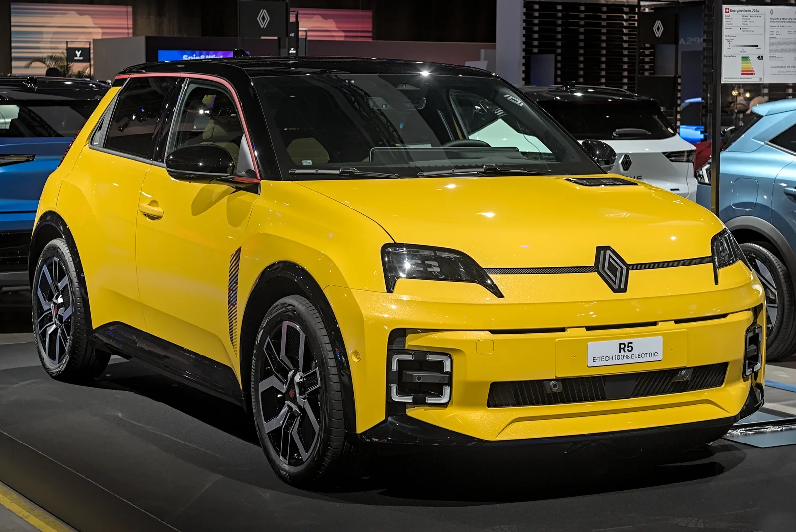 Renault 5 E-Tech Electric en jaune, au salon Auto Zürich 2024, vue 3/4 avant dans un stand épuré