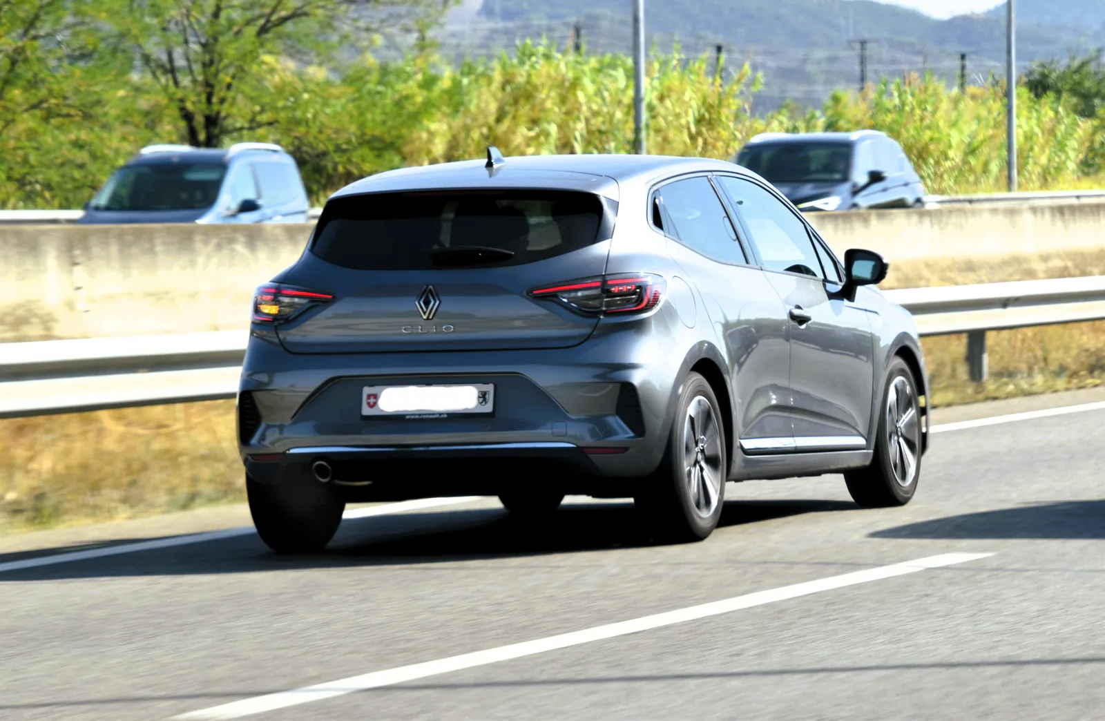 Renault Clio 6 E-Tech hybride 2026 vue arrière en mouvement sur route