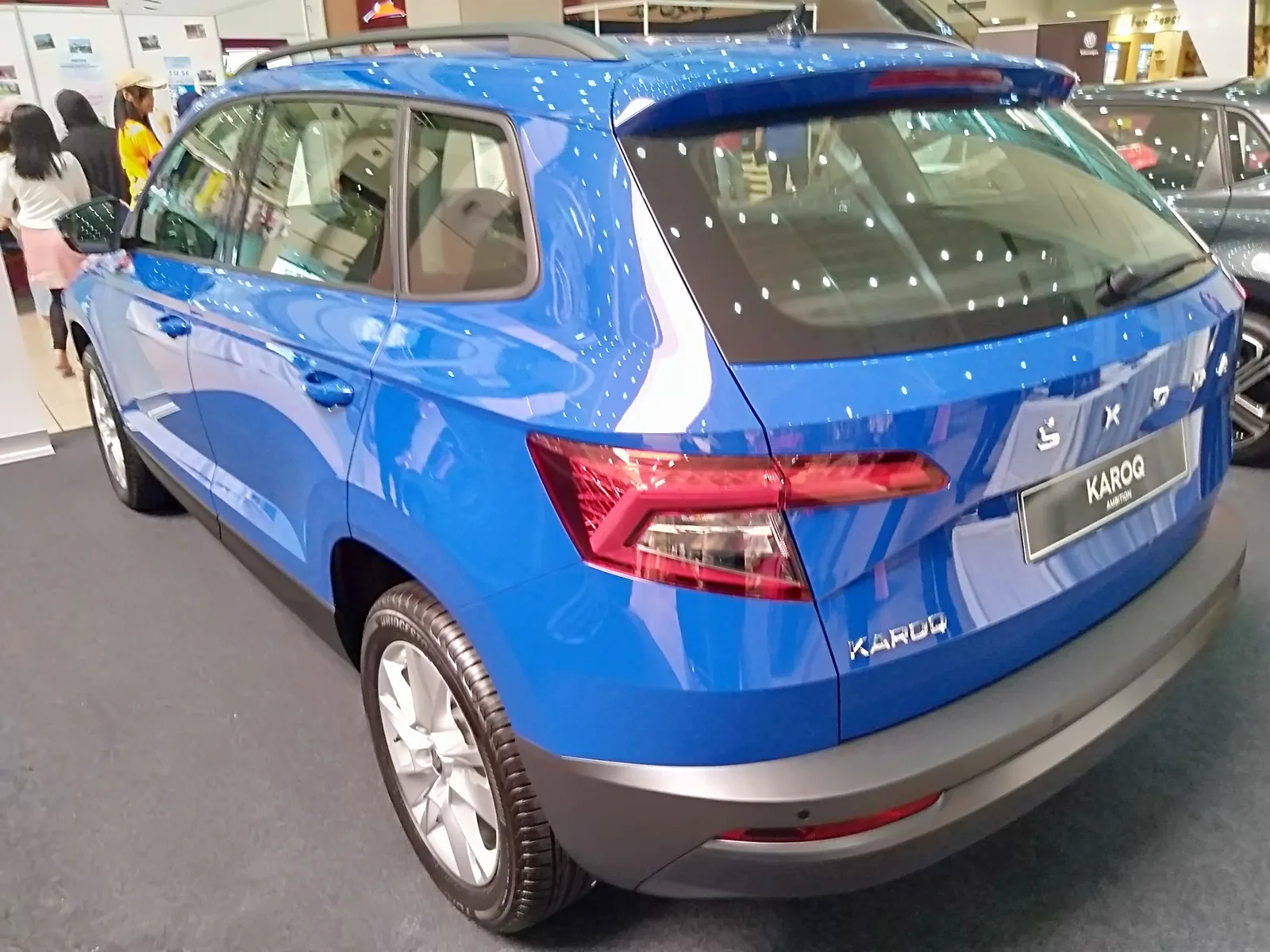 Skoda Karoq 2026 bleu Race Blue, vue arrière au salon automobile, feux LED