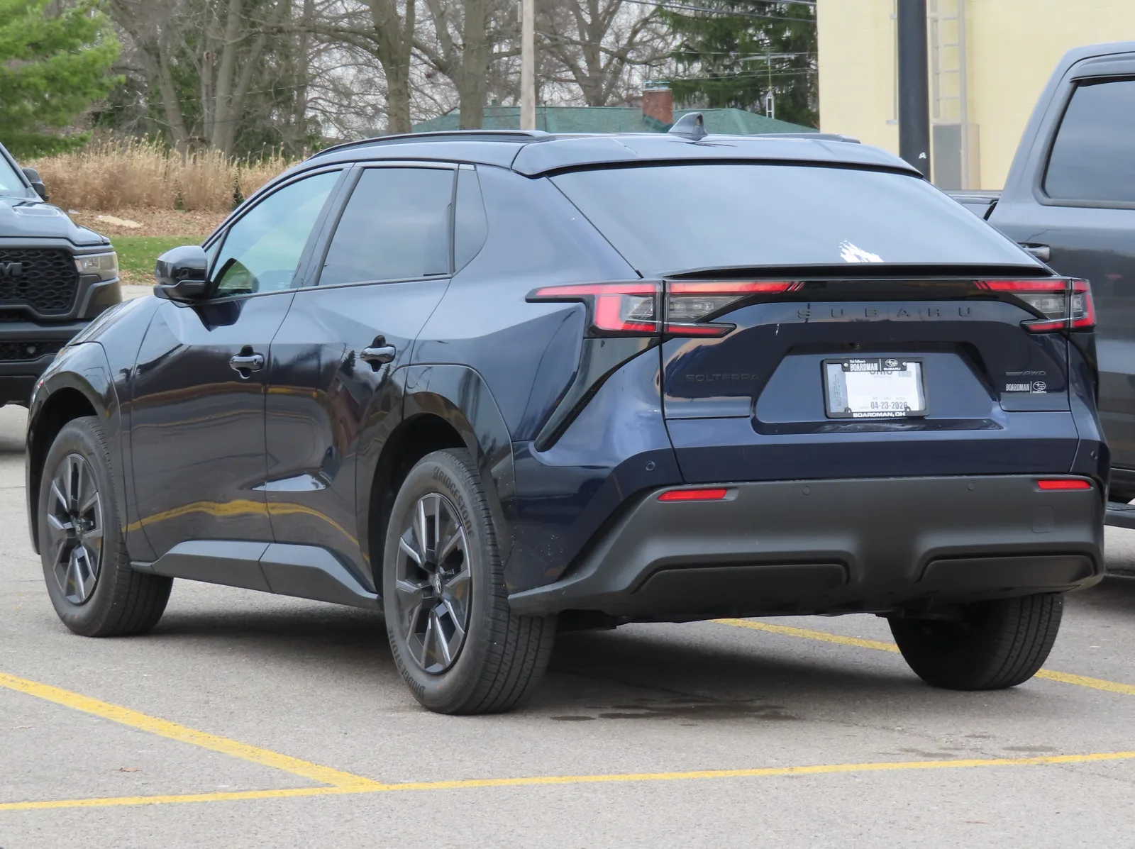 Subaru Solterra 2026 vue 3/4 arrière SUV électrique bleu foncé sur un parking
