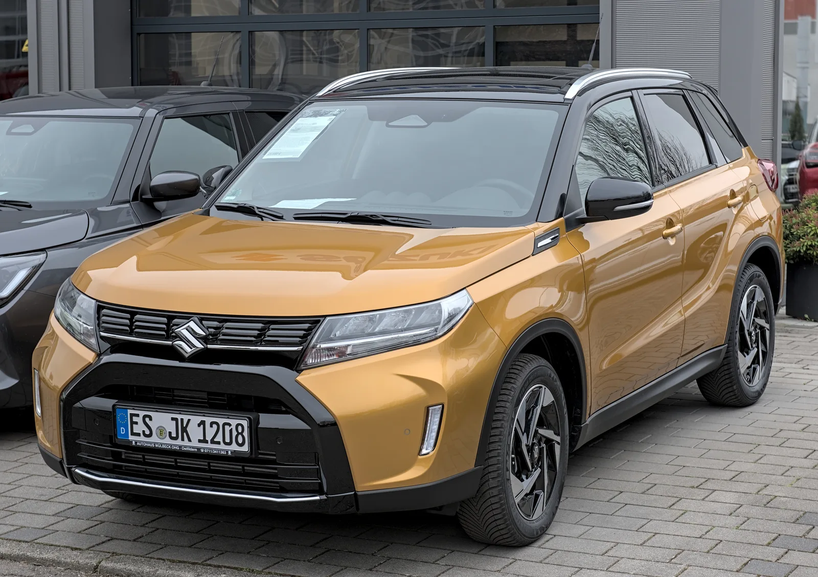 Suzuki Vitara 2026 doré vue trois quarts avant zone commerciale allemande