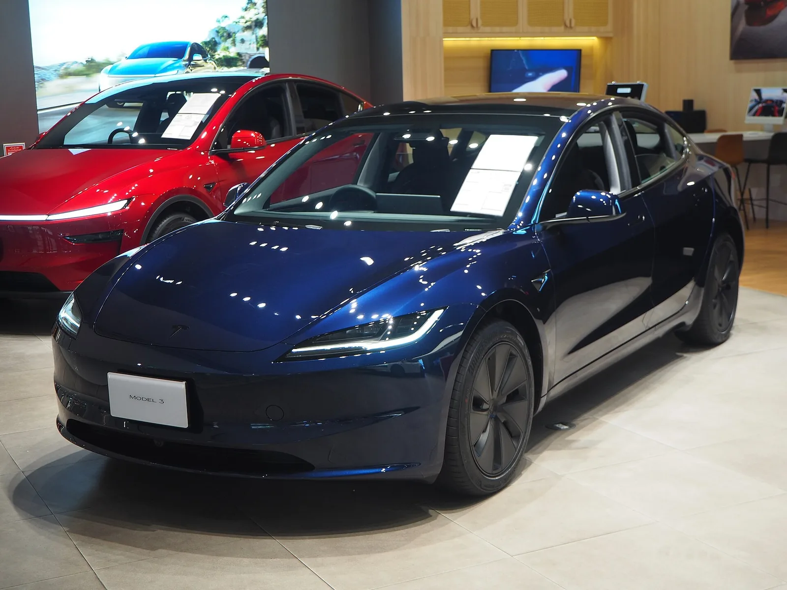 Tesla Model 3 Premium Grande Autonomie Propulsion bleu nuit exposée en showroom, berline électrique à 750 km WLTP