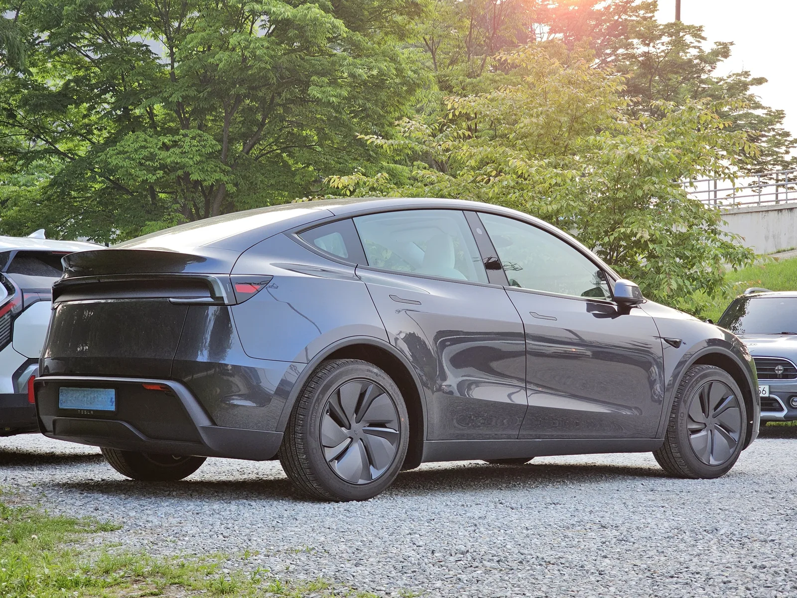 Tesla Model Y Juniper 2026 Gris Furtif — vue 3/4 arrière, hayon panoramique et feux redessinés