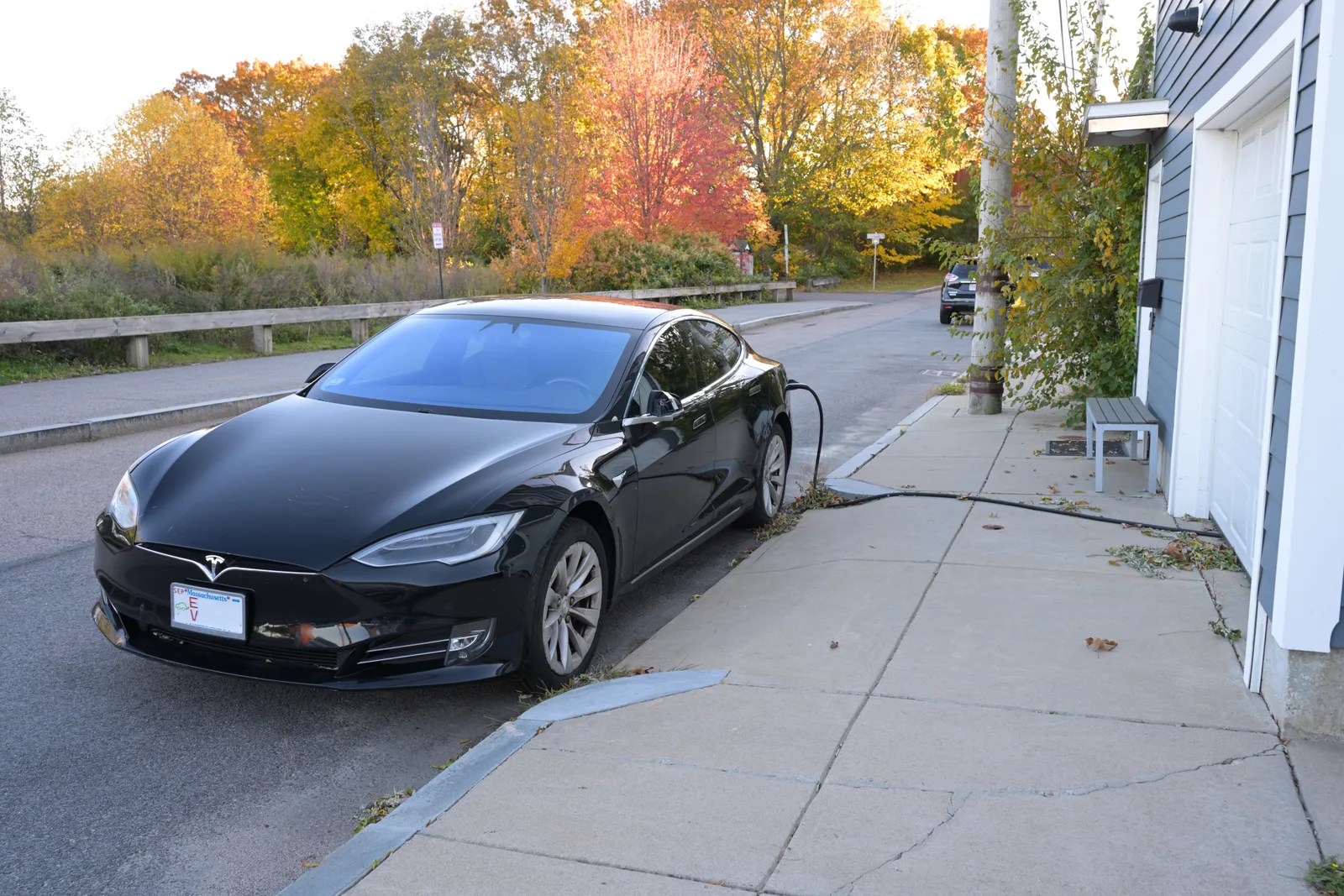Tesla Model S en charge dans un garage résidentiel via une borne wallbox fixée au mur