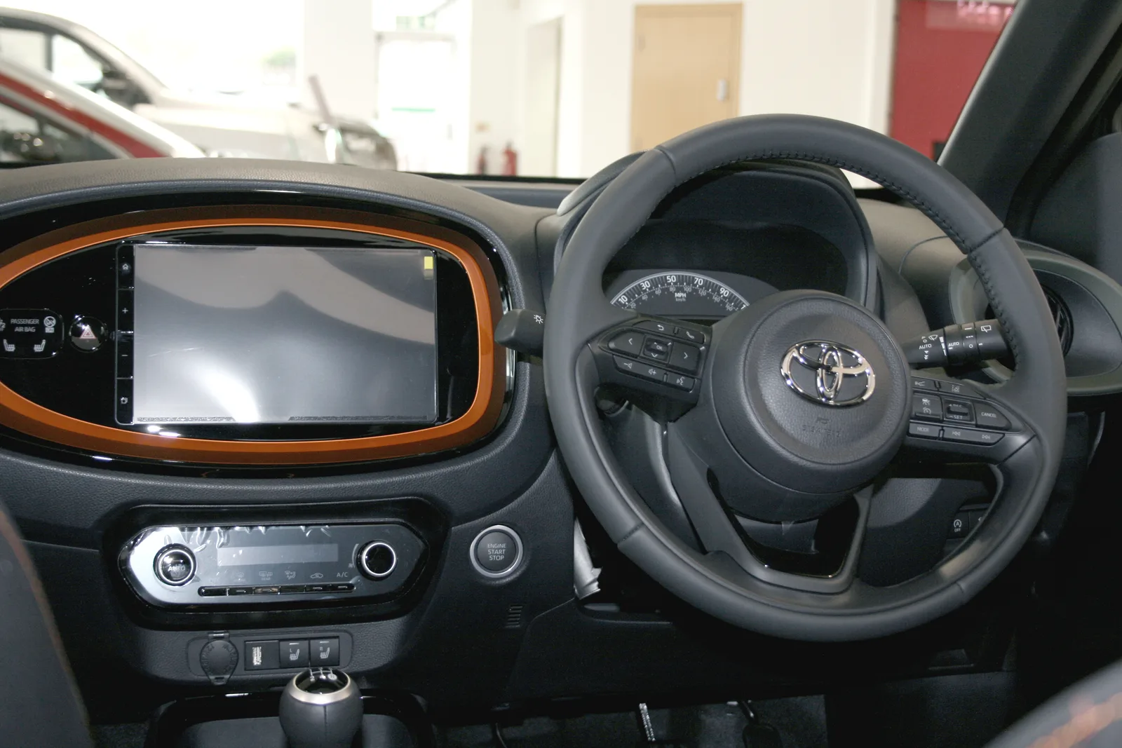 Toyota Aygo X 2026 intérieur tableau de bord avec garniture orange et écran multimédia