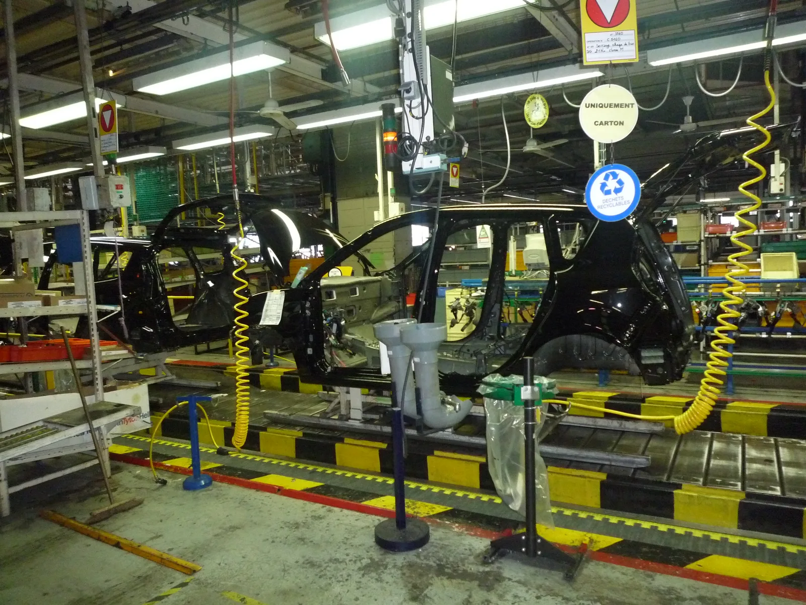 Chaîne d'assemblage de l'usine Renault de Douai avec des caisses en blanc de voitures en cours de montage