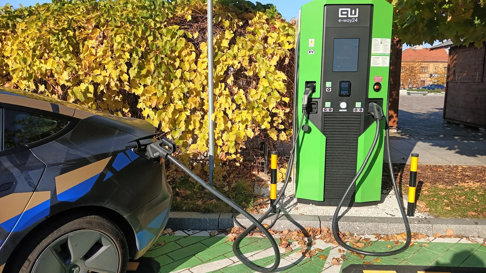 Voiture électrique branchée sur borne de recharge rapide station été 2026