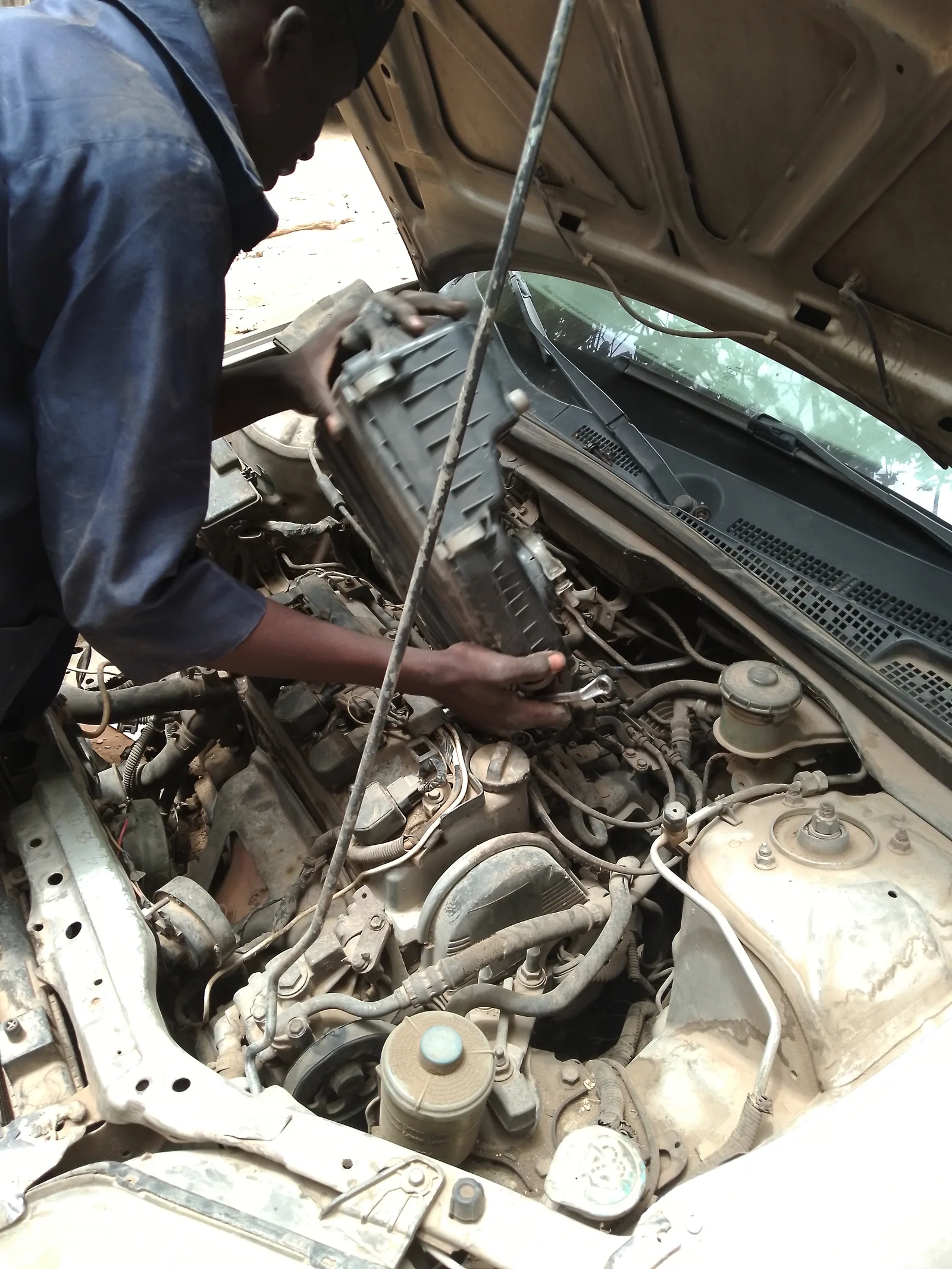 Mécanicien réparant un moteur de voiture en atelier