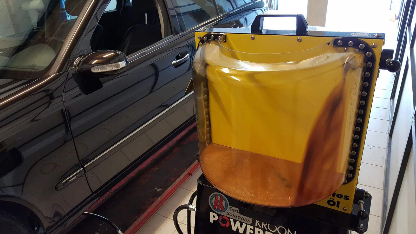 Vidange d'huile de boîte automatique avec machine de rinçage — huile usée de couleur brune foncée extraite