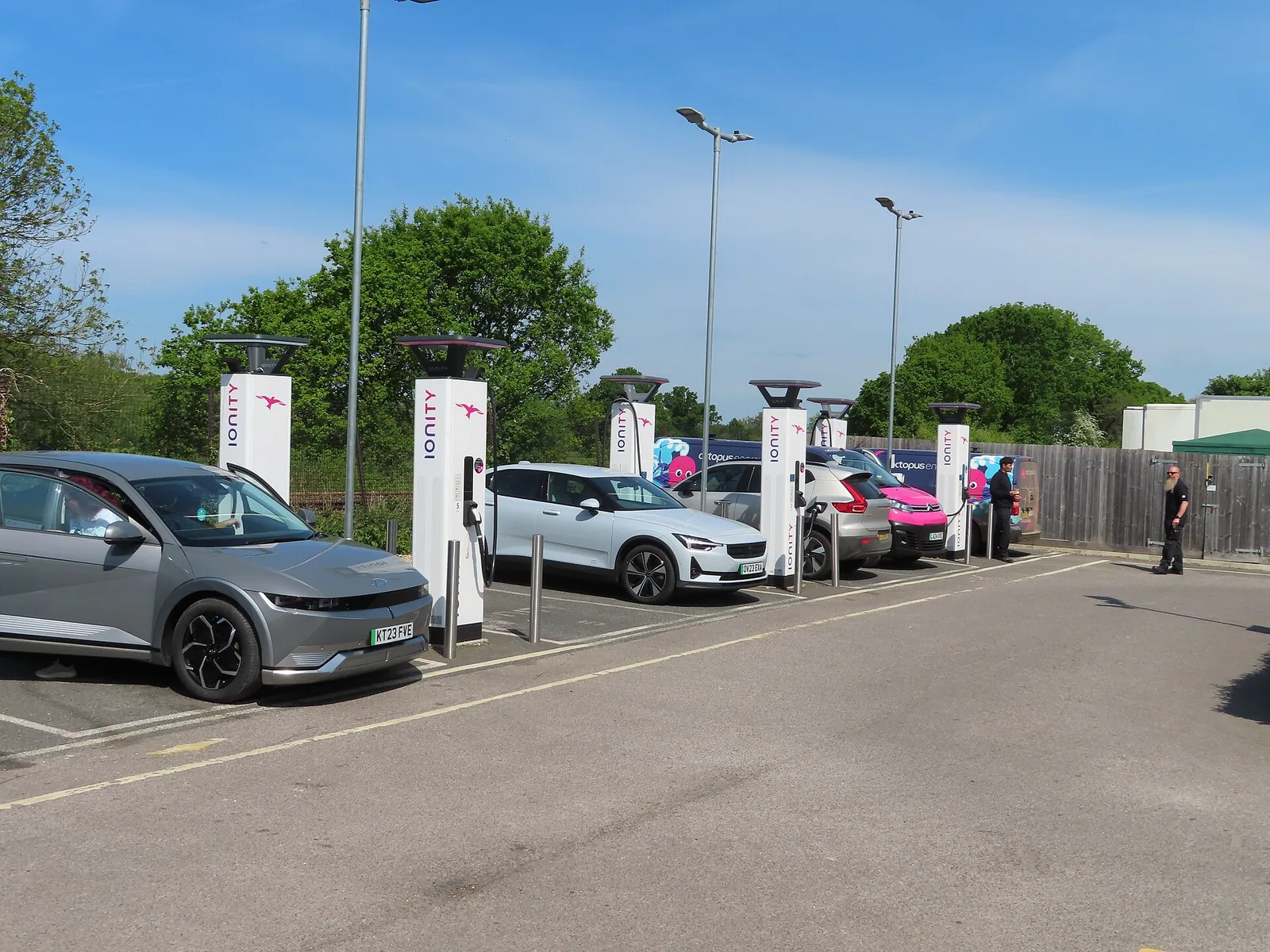 Bornes de recharge rapide Ionity et véhicules électriques en charge sur une aire de service