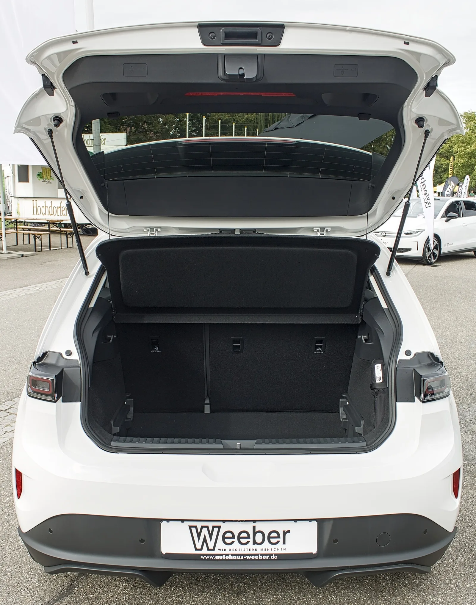 Coffre ouvert d'une Volkswagen ID. Polo blanche vu de l'arrière, volume de 441 litres contre 326 litres pour la Renault 5