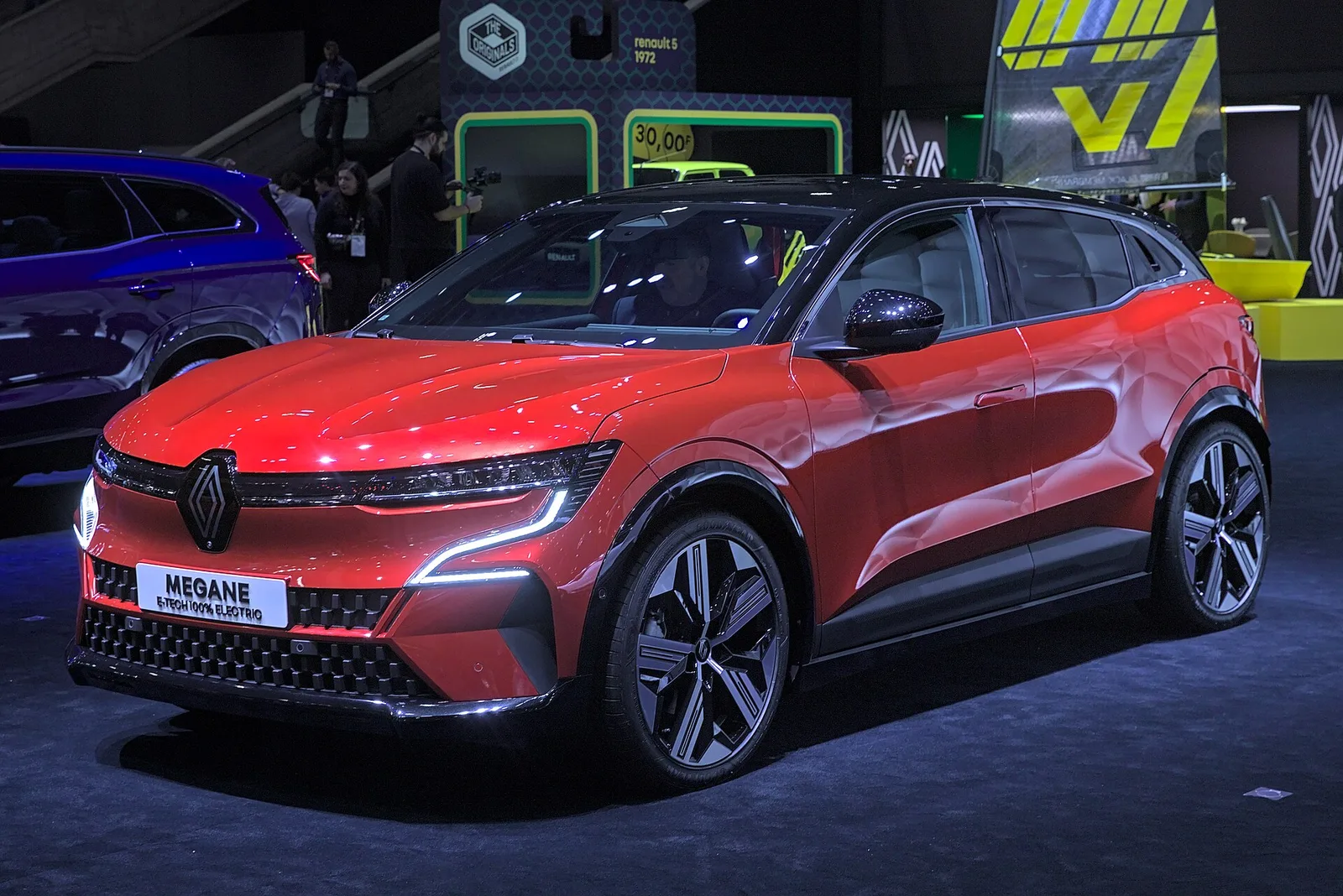 Renault Mégane E-Tech rouge exposée sur un stand de salon automobile