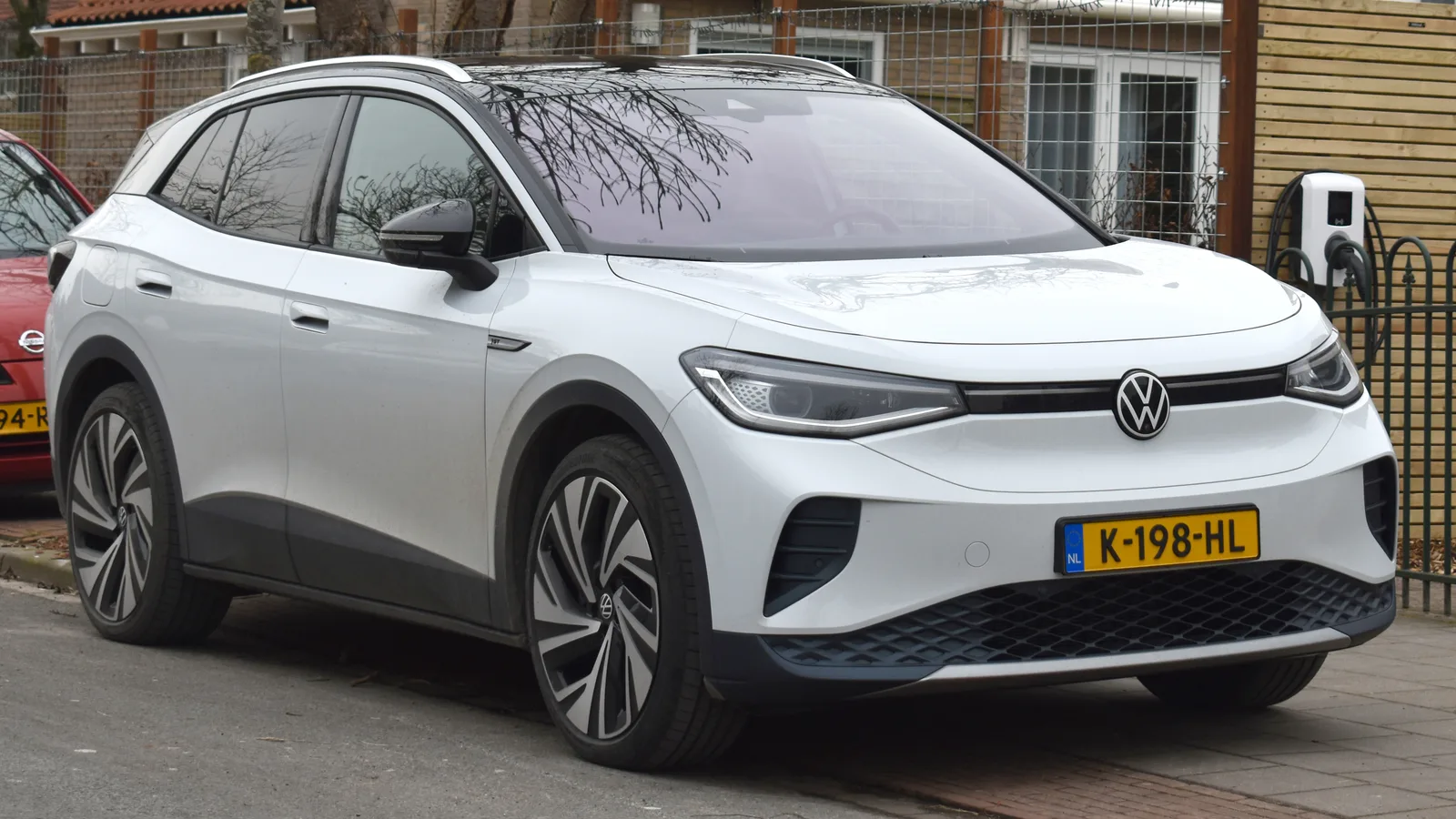 Volkswagen ID.4 2026 blanc branché sur une borne de recharge résidentielle — charge AC à domicile