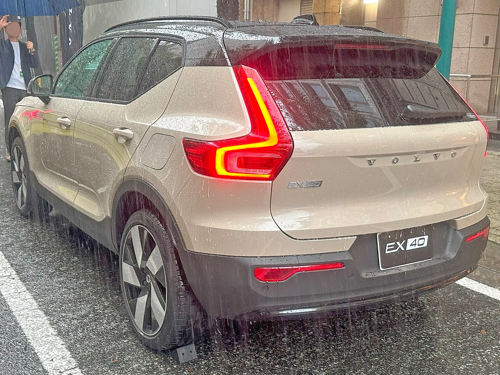 Volvo EX40 sable vue trois quarts arrière avec feux arrière et badge EX40 sur le hayon