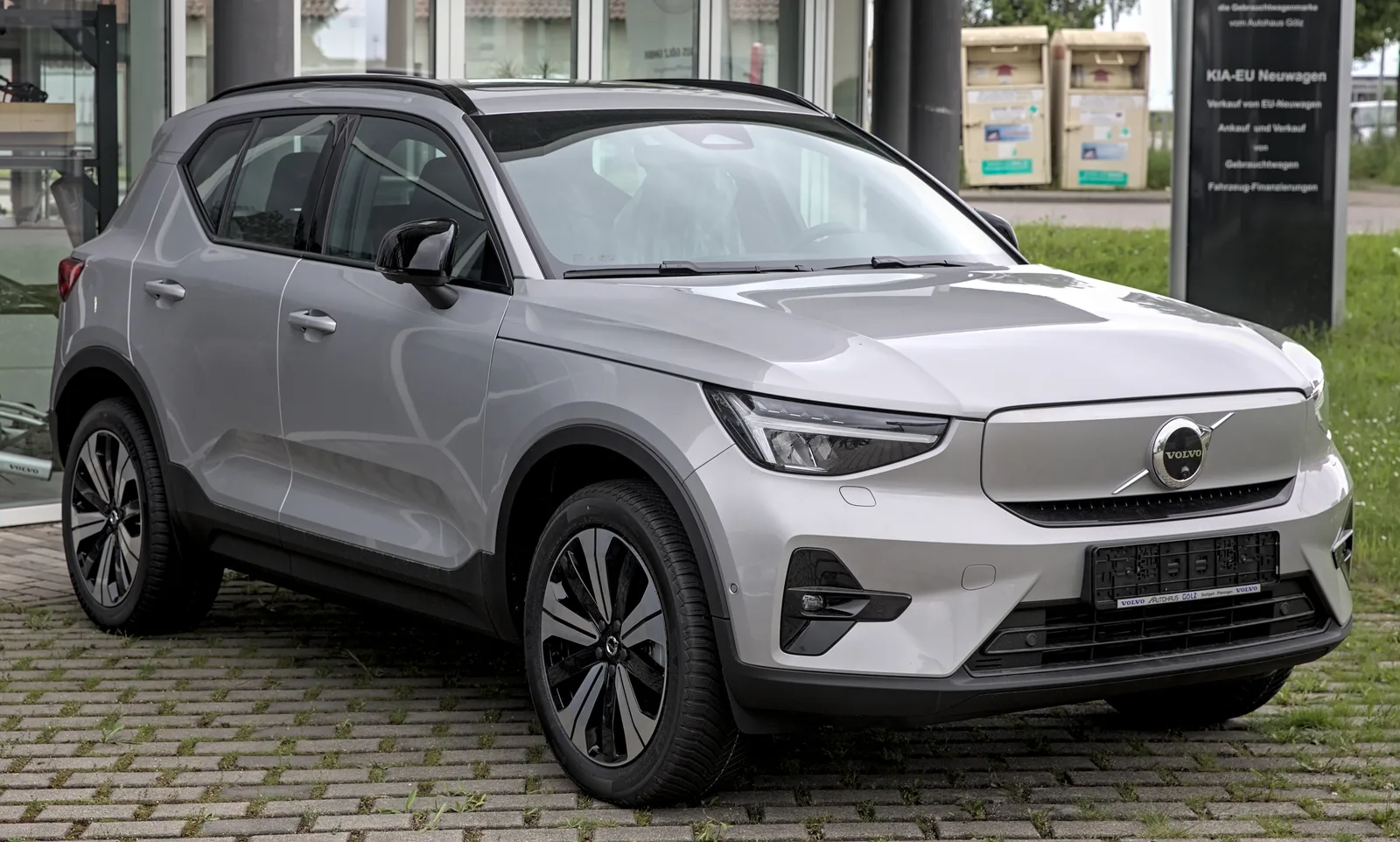 Volvo EX40 gris vu de trois quarts avant devant une concession, SUV électrique compact premium à grande autonomie